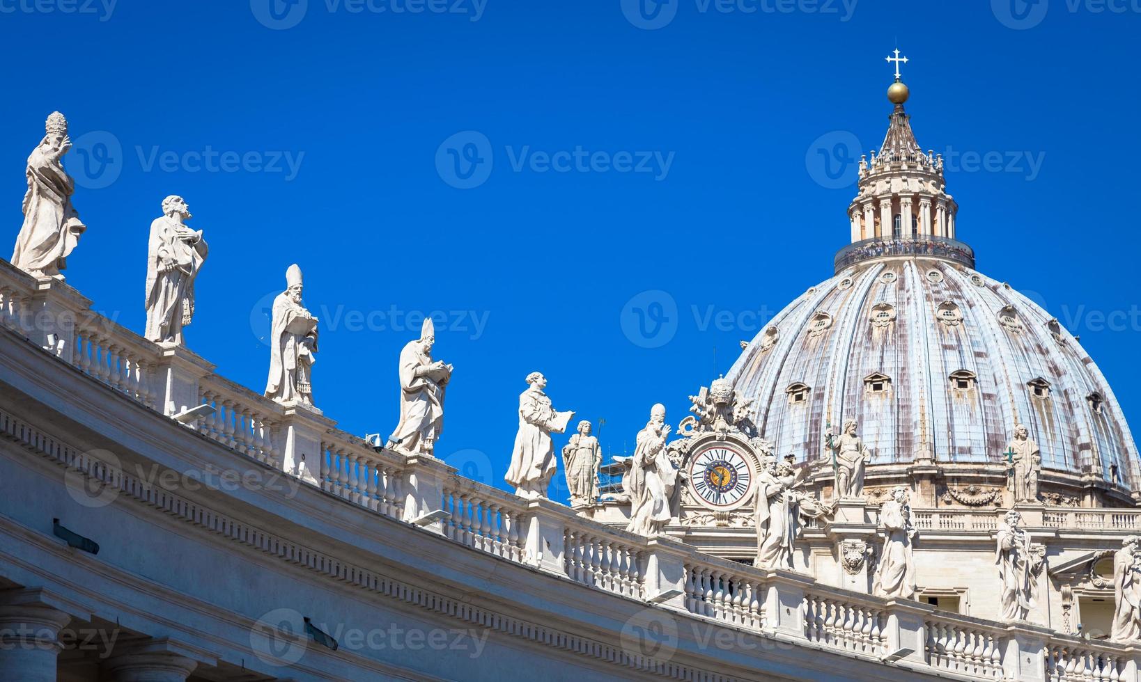 Decoración de estatuas en la catedral de San Pedro con la cúpula de fondo - Roma, Italia foto