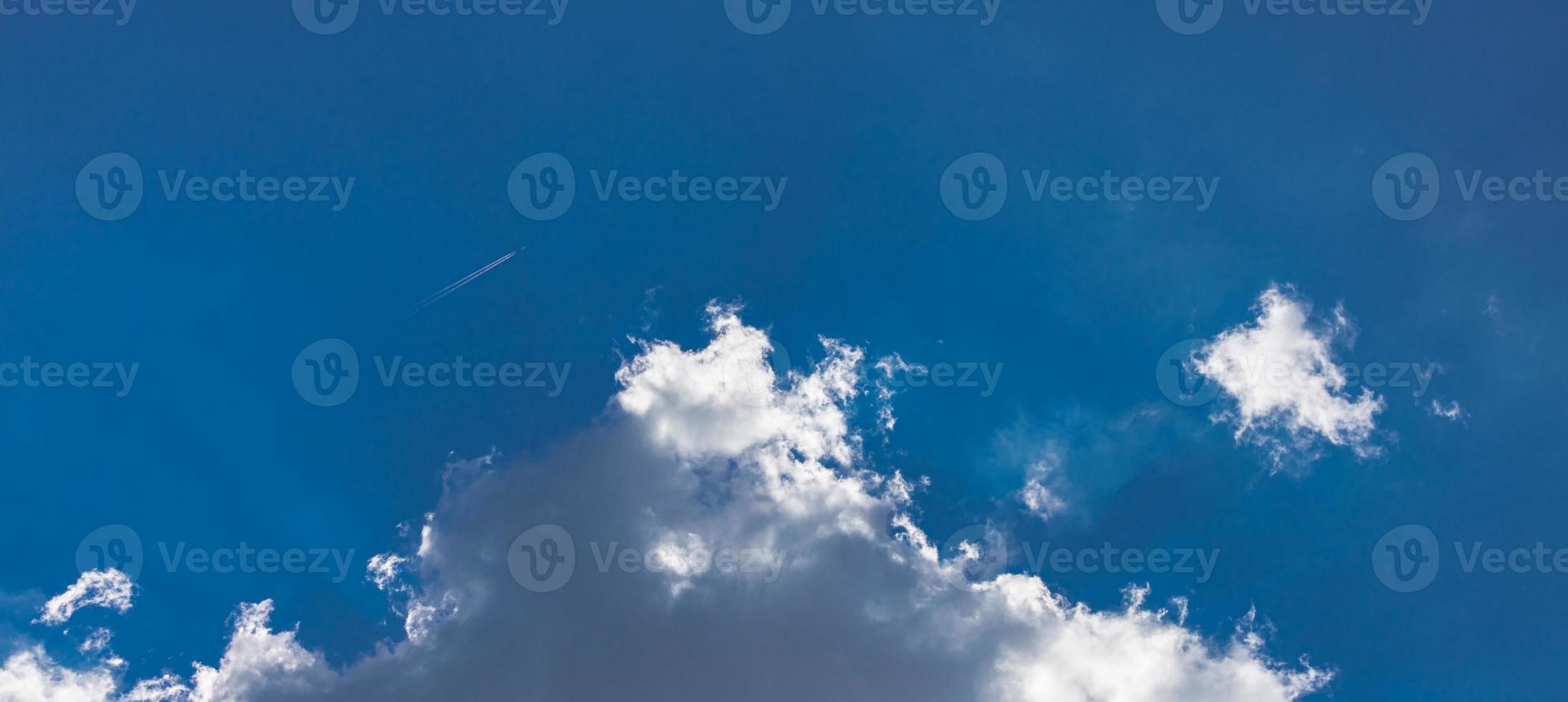 Blue sky background with clouds and rays. Sun light rays or beams bursting from the clouds on a blue sky. Spiritual religious background. photo