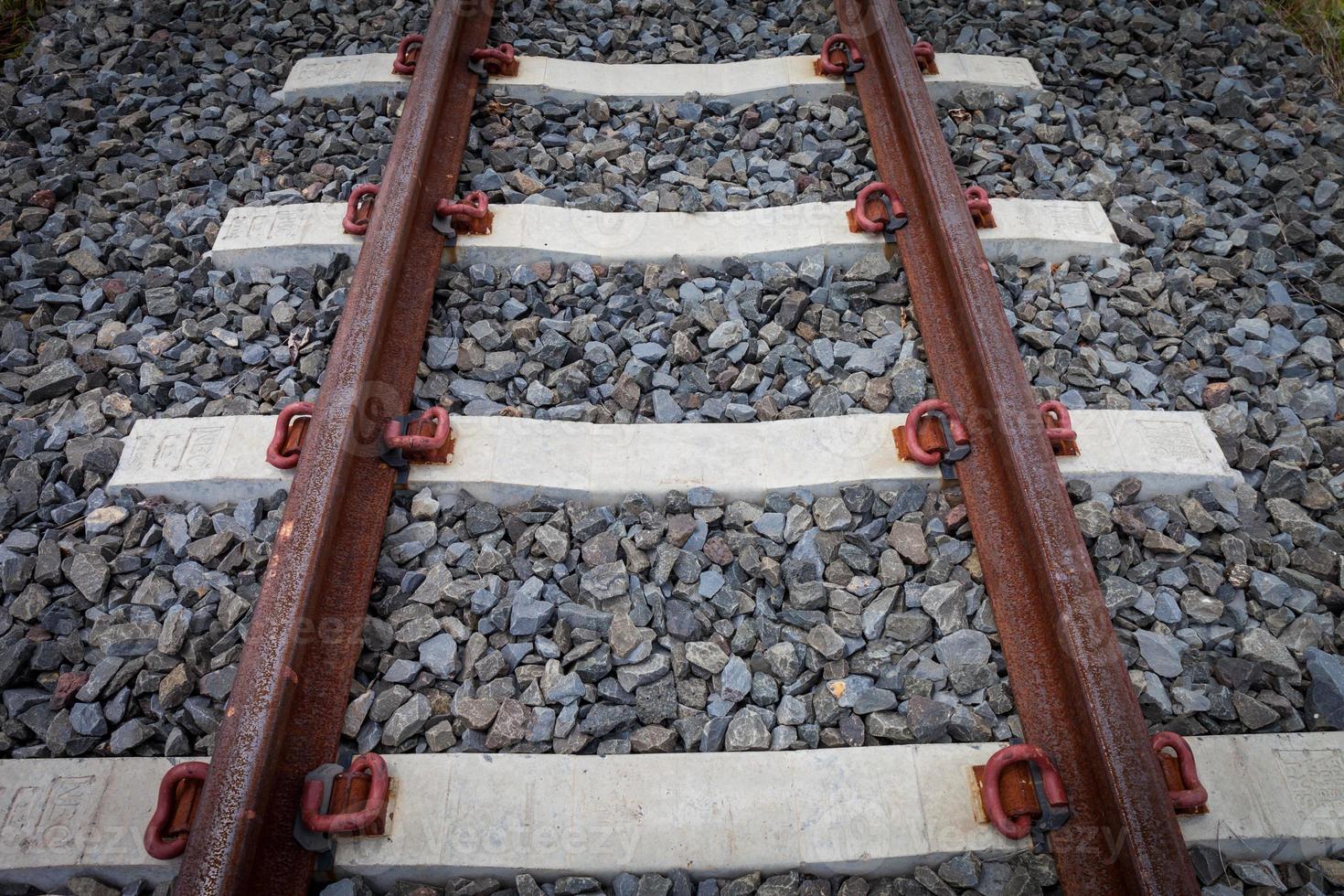 railroad tracks with rust on rock background photo