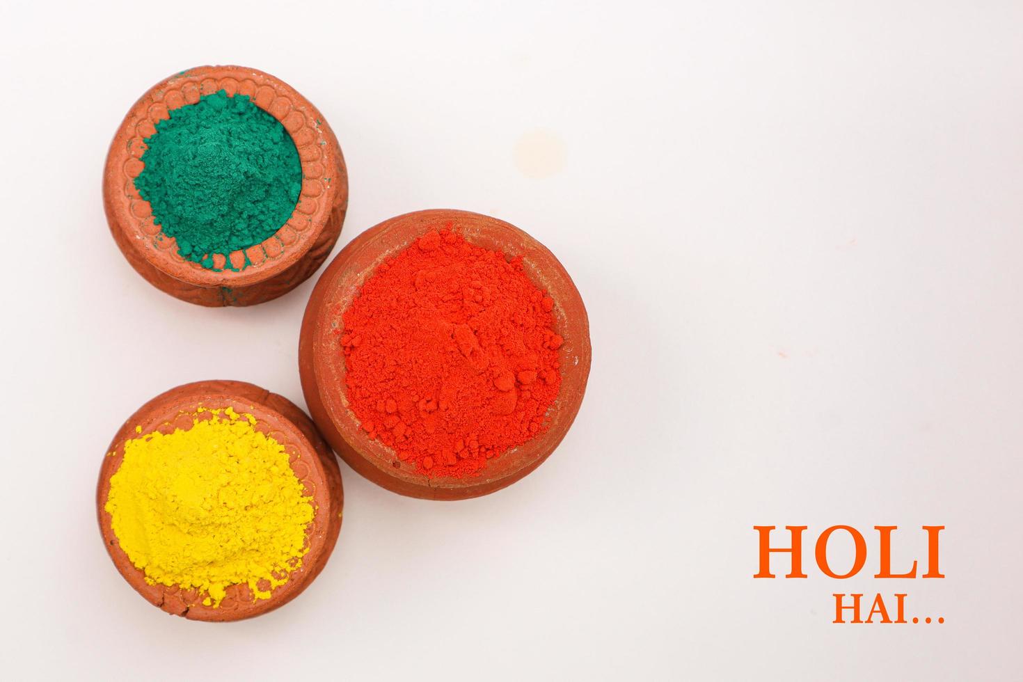 Indian festival Holi concept Multi color's bowl with colorful background and writing happy holi photo
