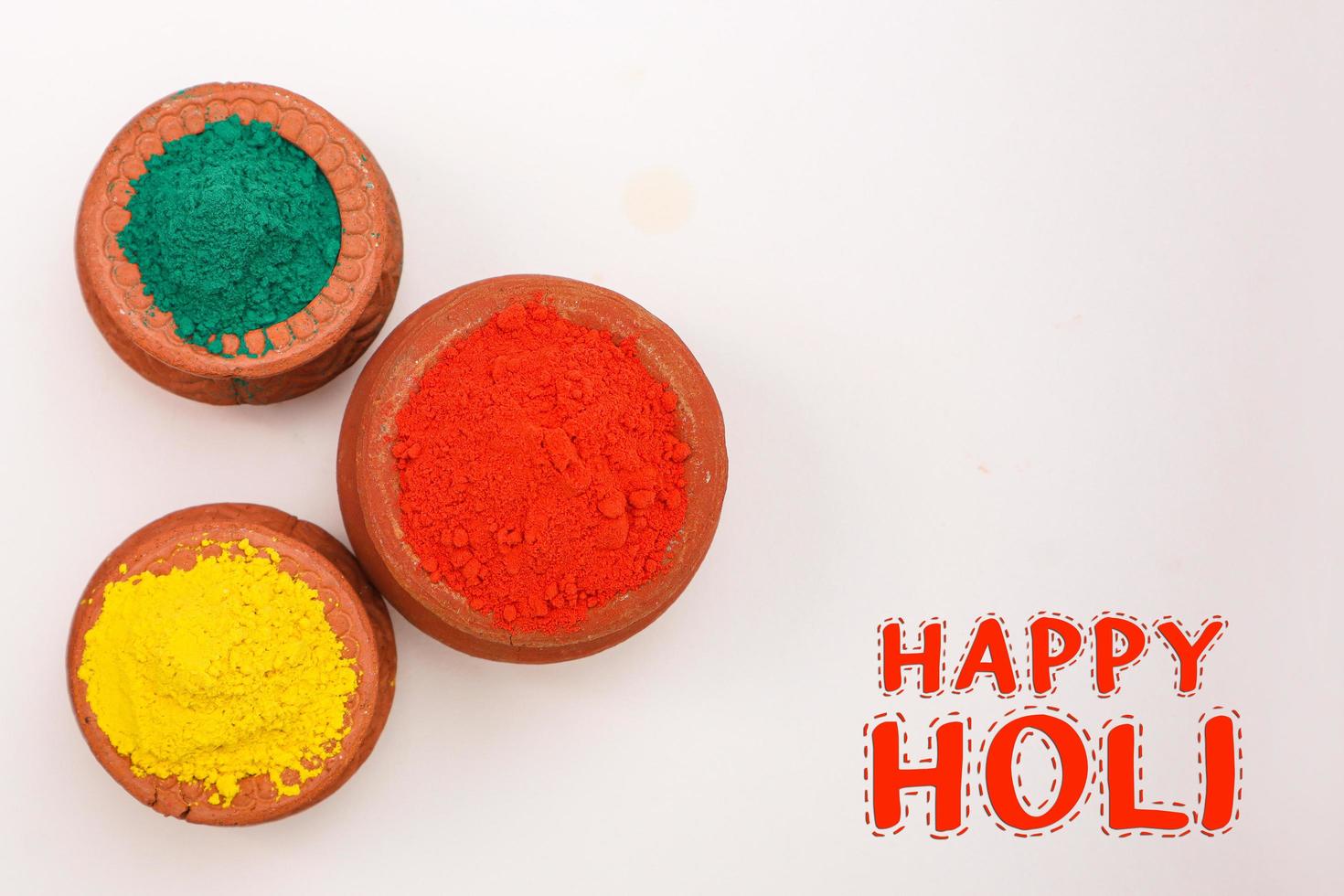 Indian festival Holi concept Multi color's bowl with colorful background and writing happy holi photo