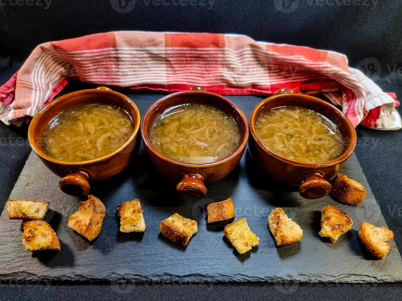 Fresh French onion soup with coutons and cheese topping photo