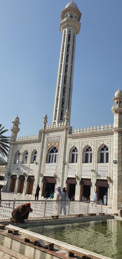 islamabad, pakistán - 2022, jama masjid golra sharif mezquita pintoresca vista impresionante con visitantes musulmanes lavándose las manos en un día soleado foto