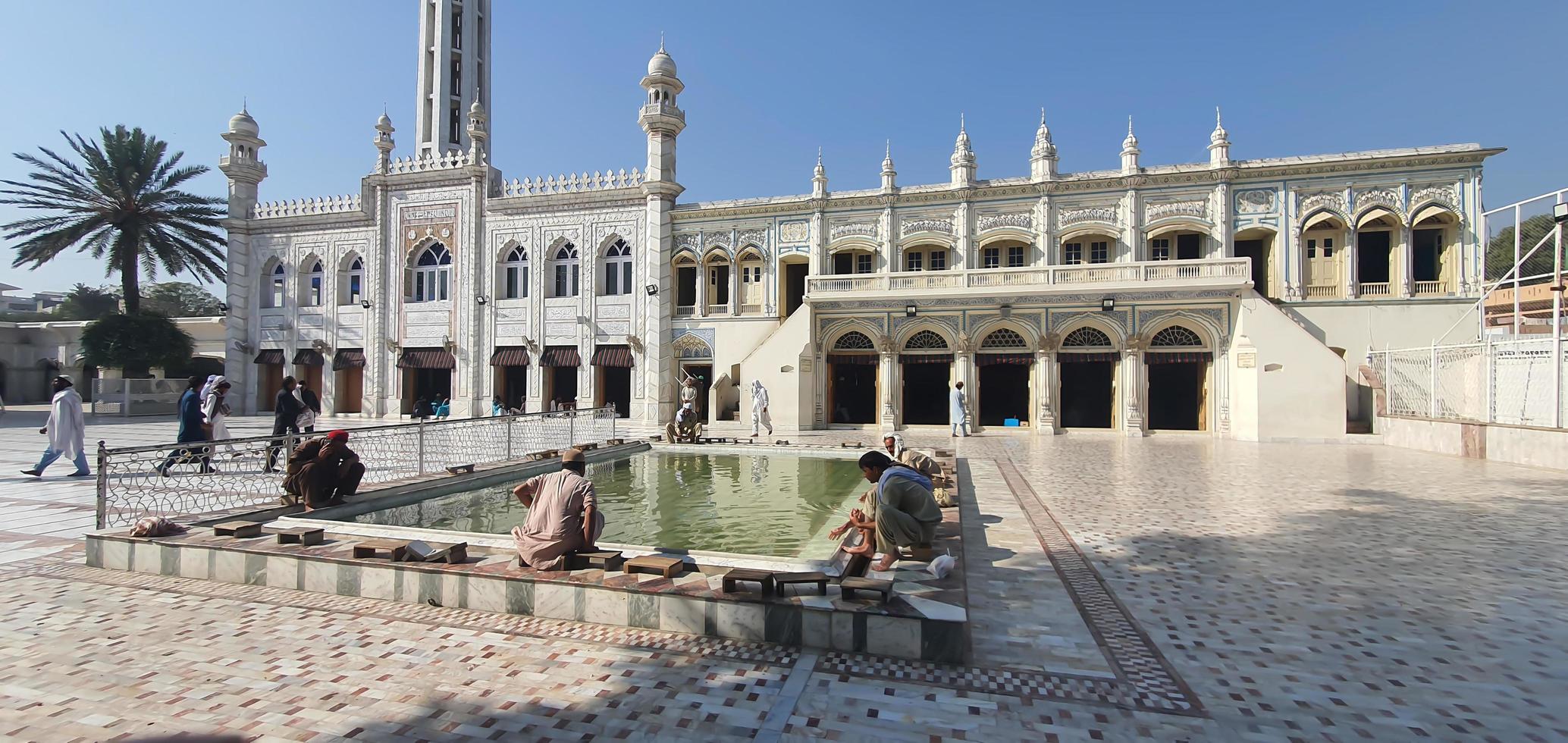 islamabad, punjab, pakistán - 2021, jama masjid golra sharif mezquita pintoresca vista impresionante con visitantes musulmanes lavándose los pies y las manos en un día soleado foto