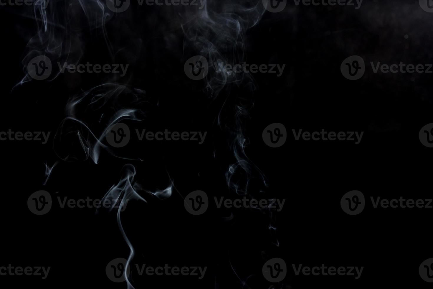 Abstract smoke swirls on black background photo