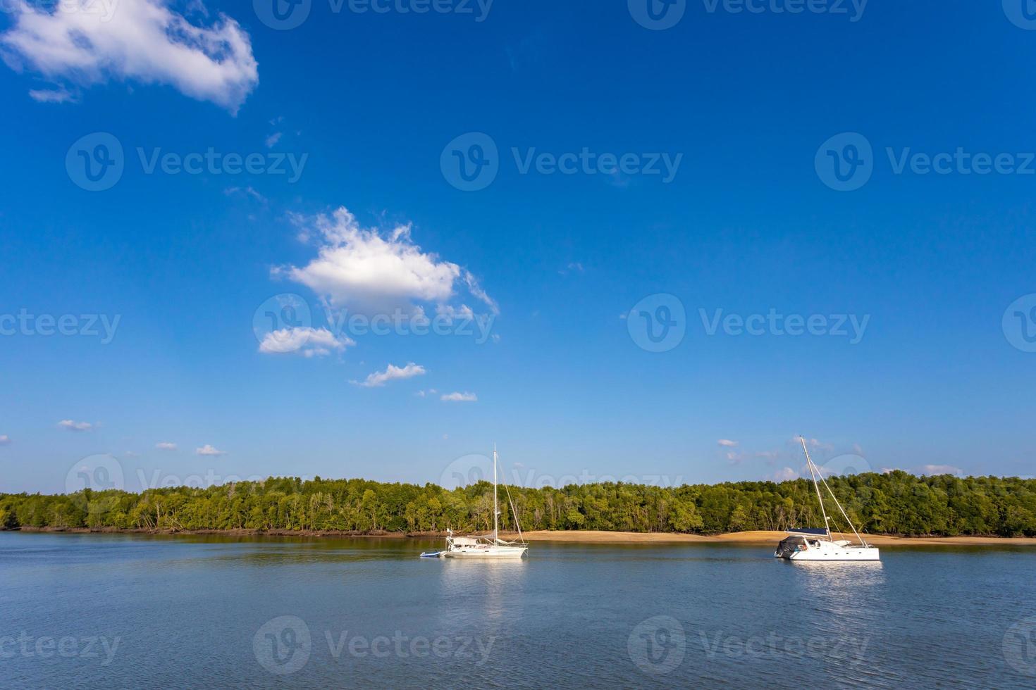 KRABI, THAILAND - JANUARY 22, 2020 - Beautiful natural view of sailboat, boats, pier, mangrove forest and Khao Khanab Nam mountain at Krabi River, Krabi, Thailand. photo