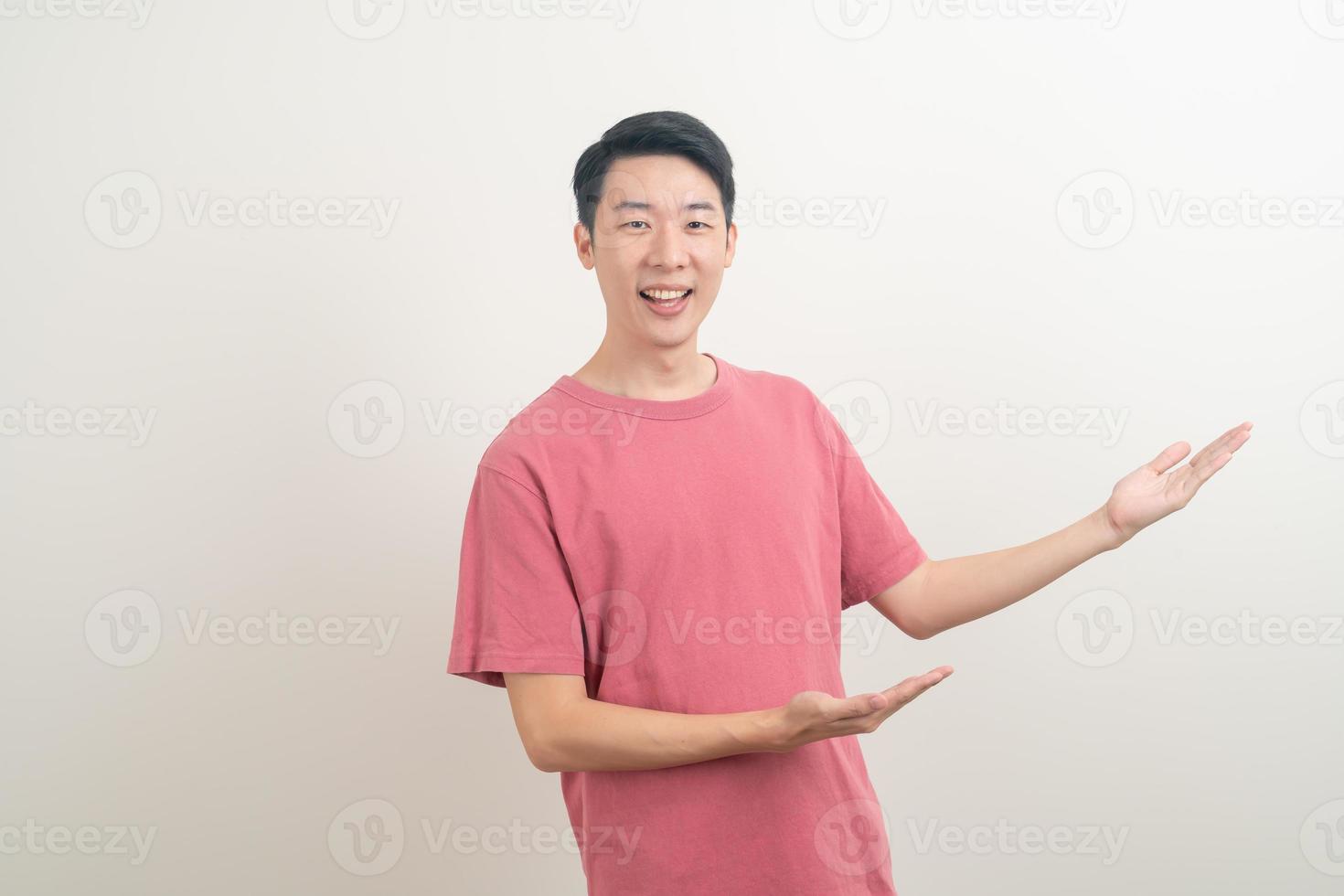 Hombre asiático con la mano apuntando o presentando sobre fondo blanco. foto