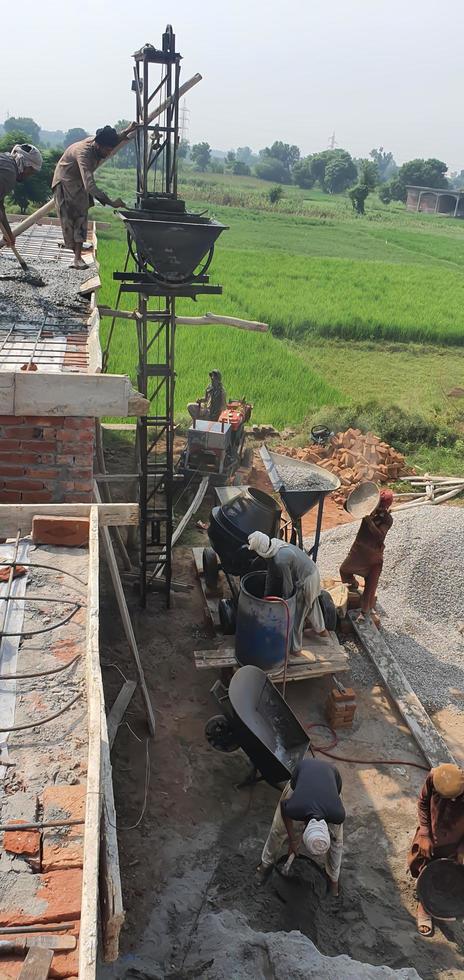Sialkot, Pakistan - 2022, A group of unidentified labourers working at a construction site in outdoor Sialkot, Pakistan photo