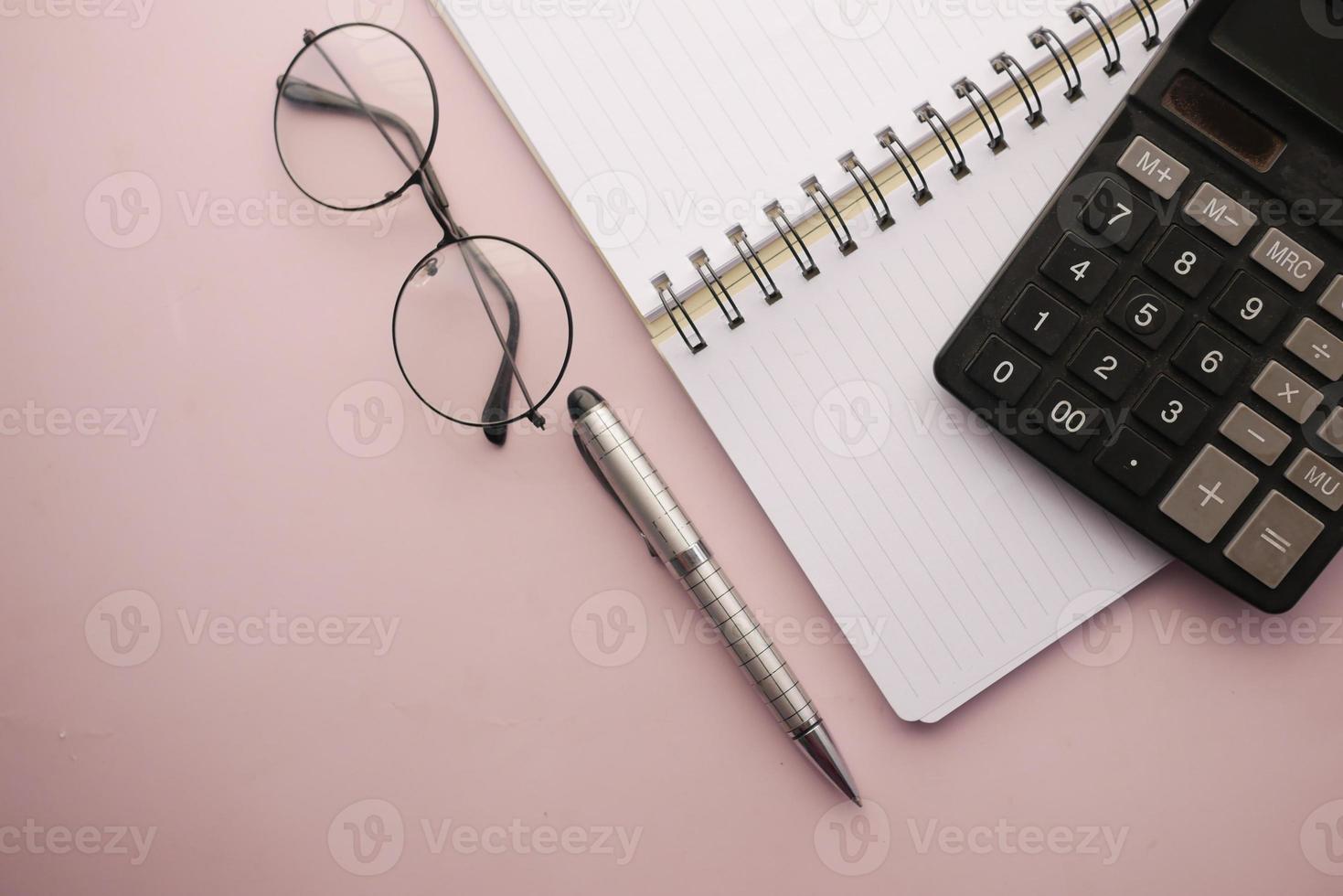 black color calculator and notepad on color background photo