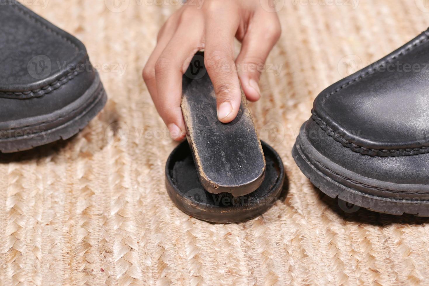 cleaning Shoe with a brush on floor photo