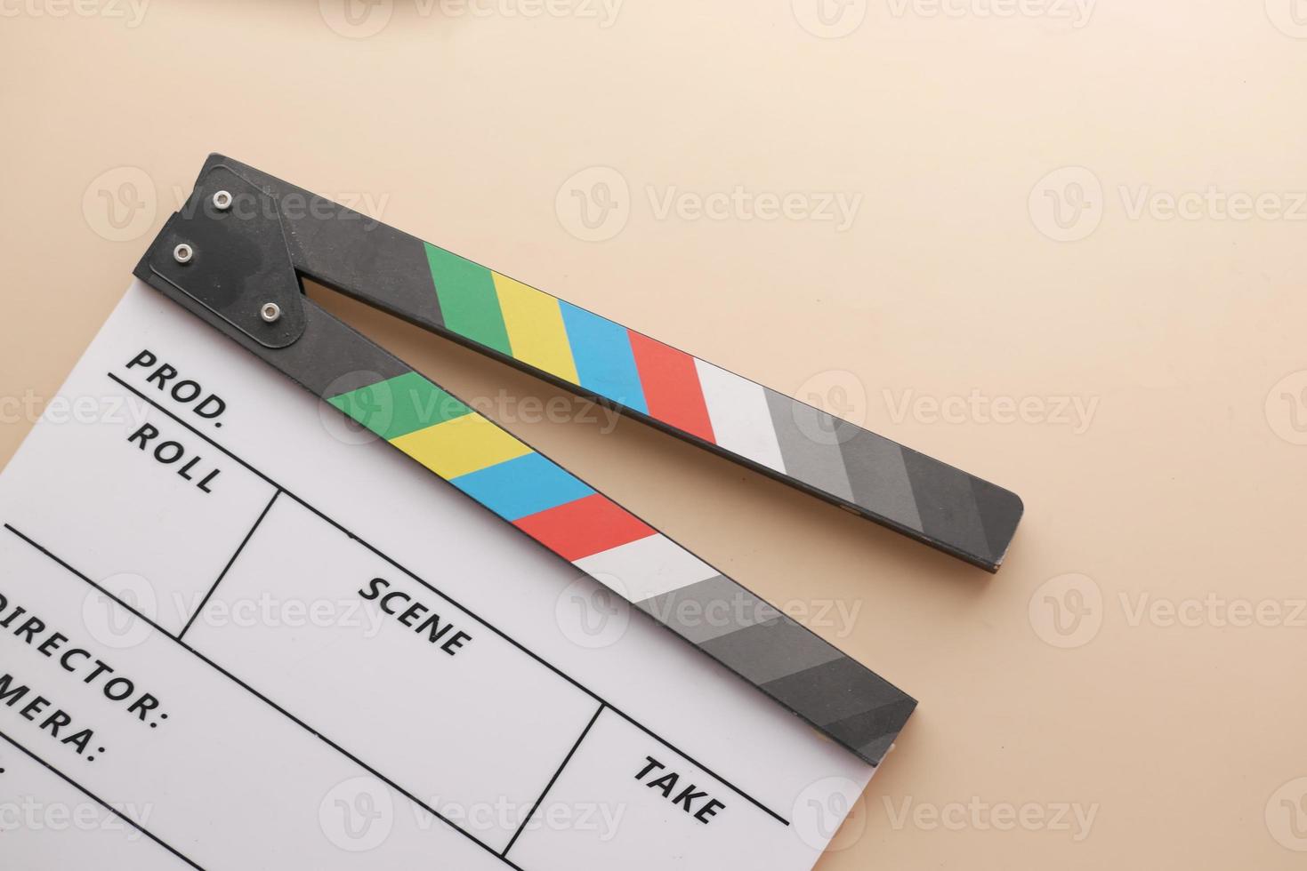 Movie clapper board against light yellow background photo