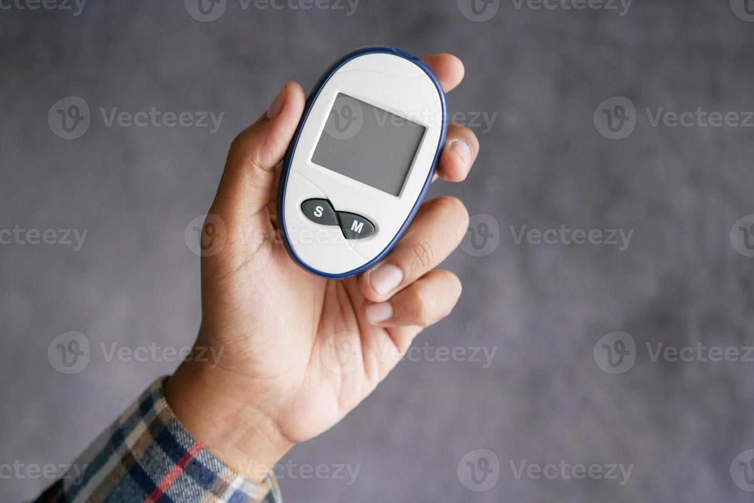 man's hand measuring blood sugar level photo