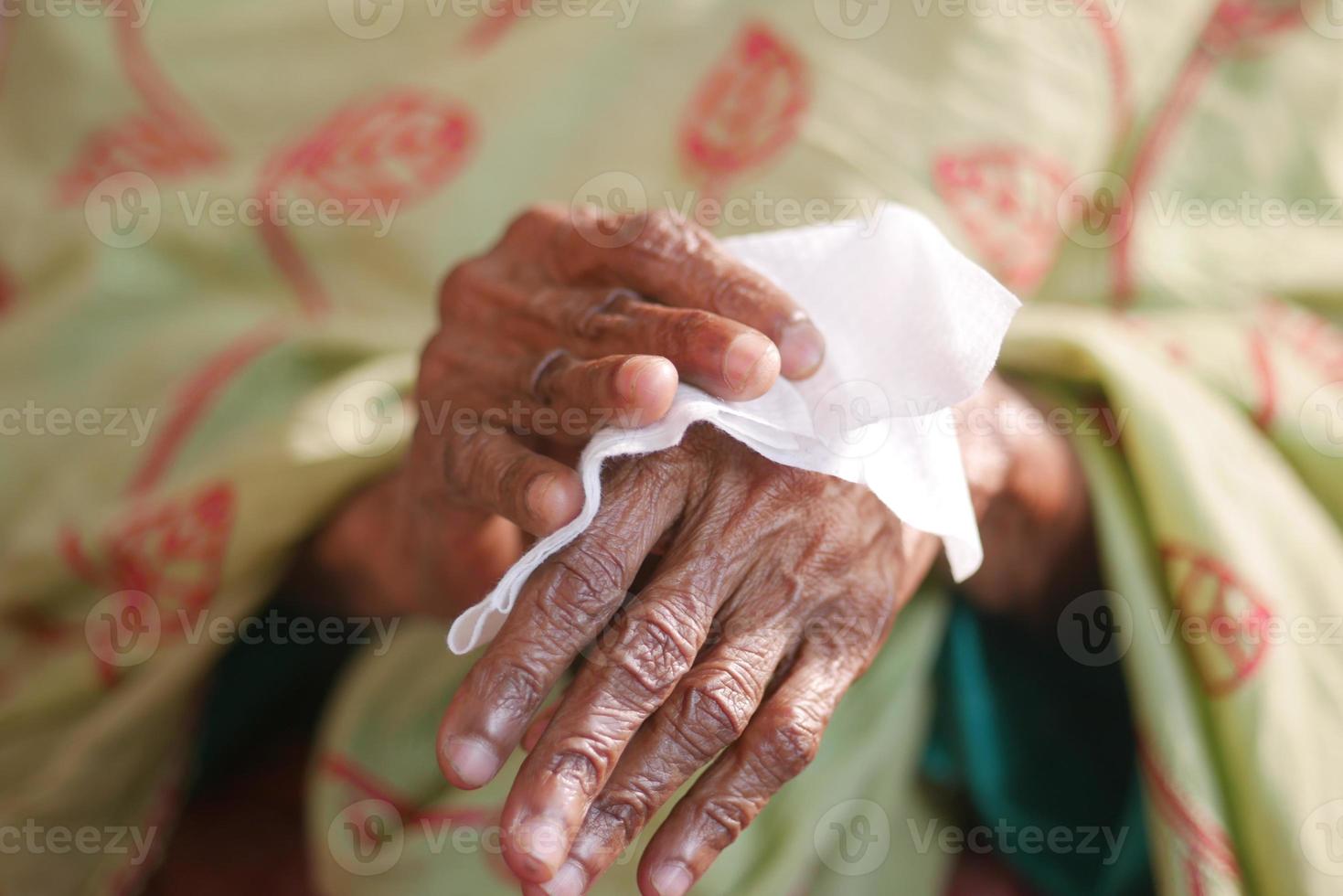 senior women disinfecting his hands with a wet wipe. photo