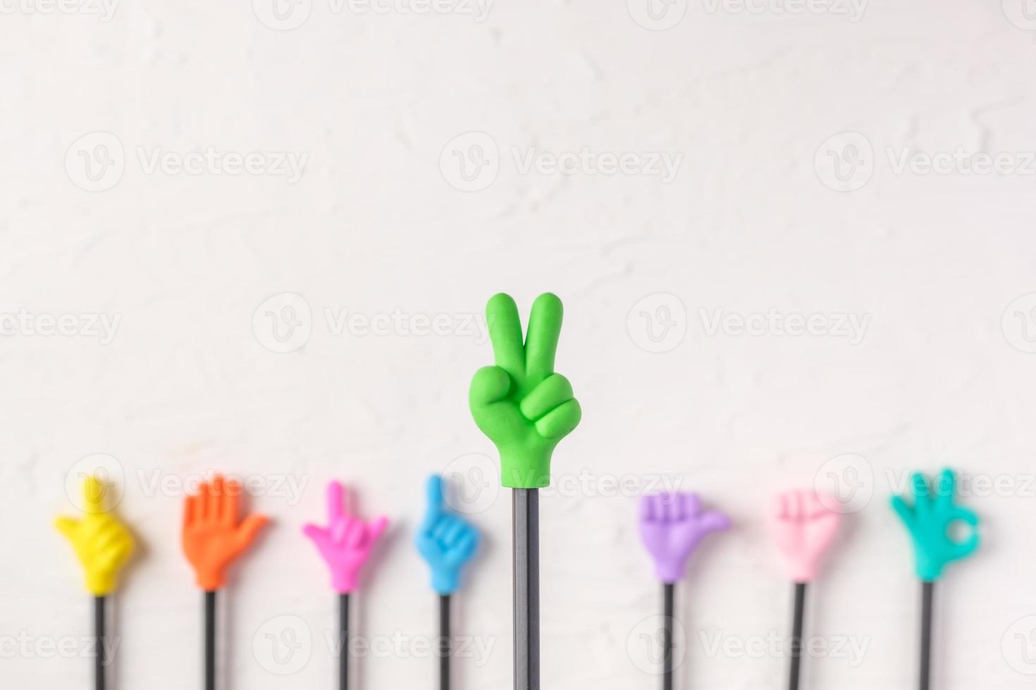 group of toy two finger hand gesture on pencil with white paster concrete background photo