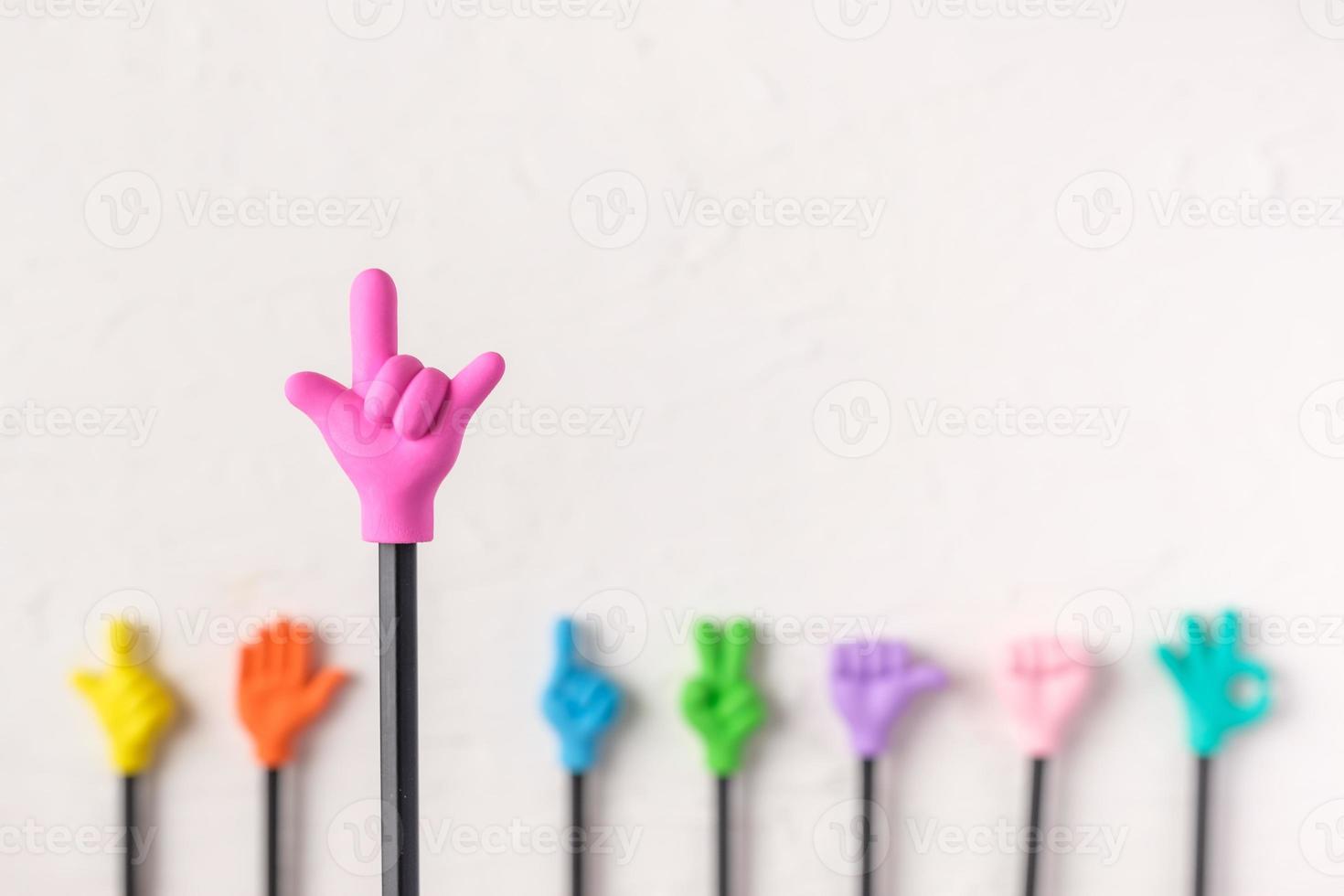 group of toy love hand gesture on pencil with white paster concrete background photo