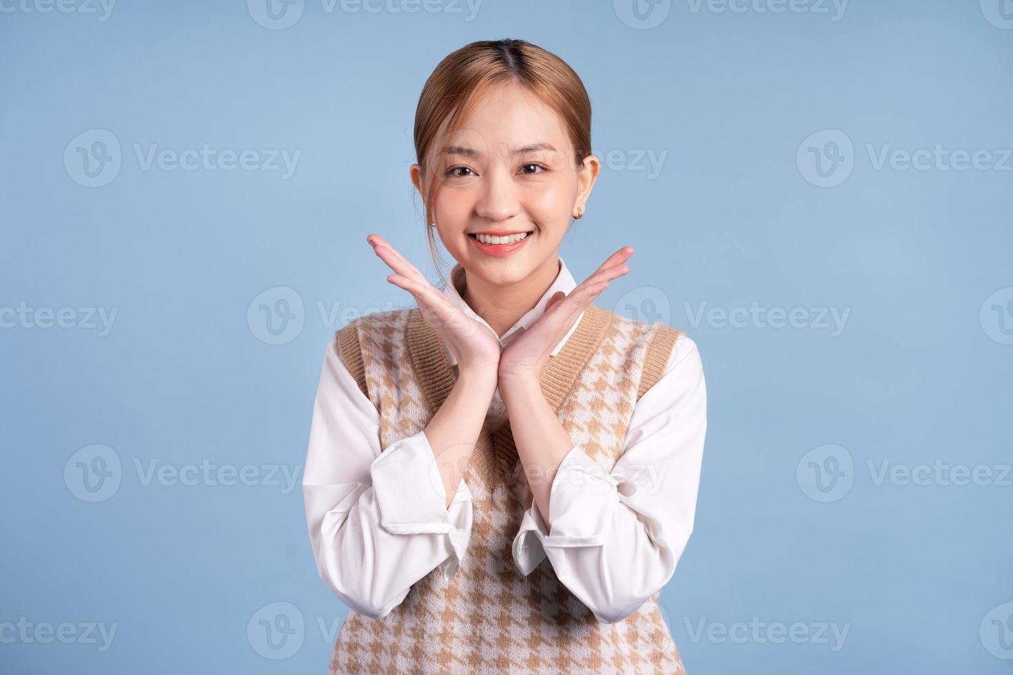 Young Asian teenager on blue background photo