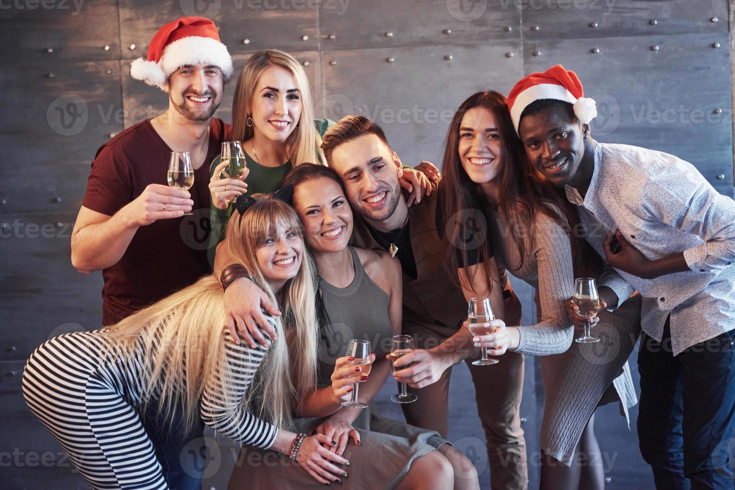 New Year is coming. Group of cheerful young multiethnic people in Santa hats on the party, posing emotional lifestyle people concept photo