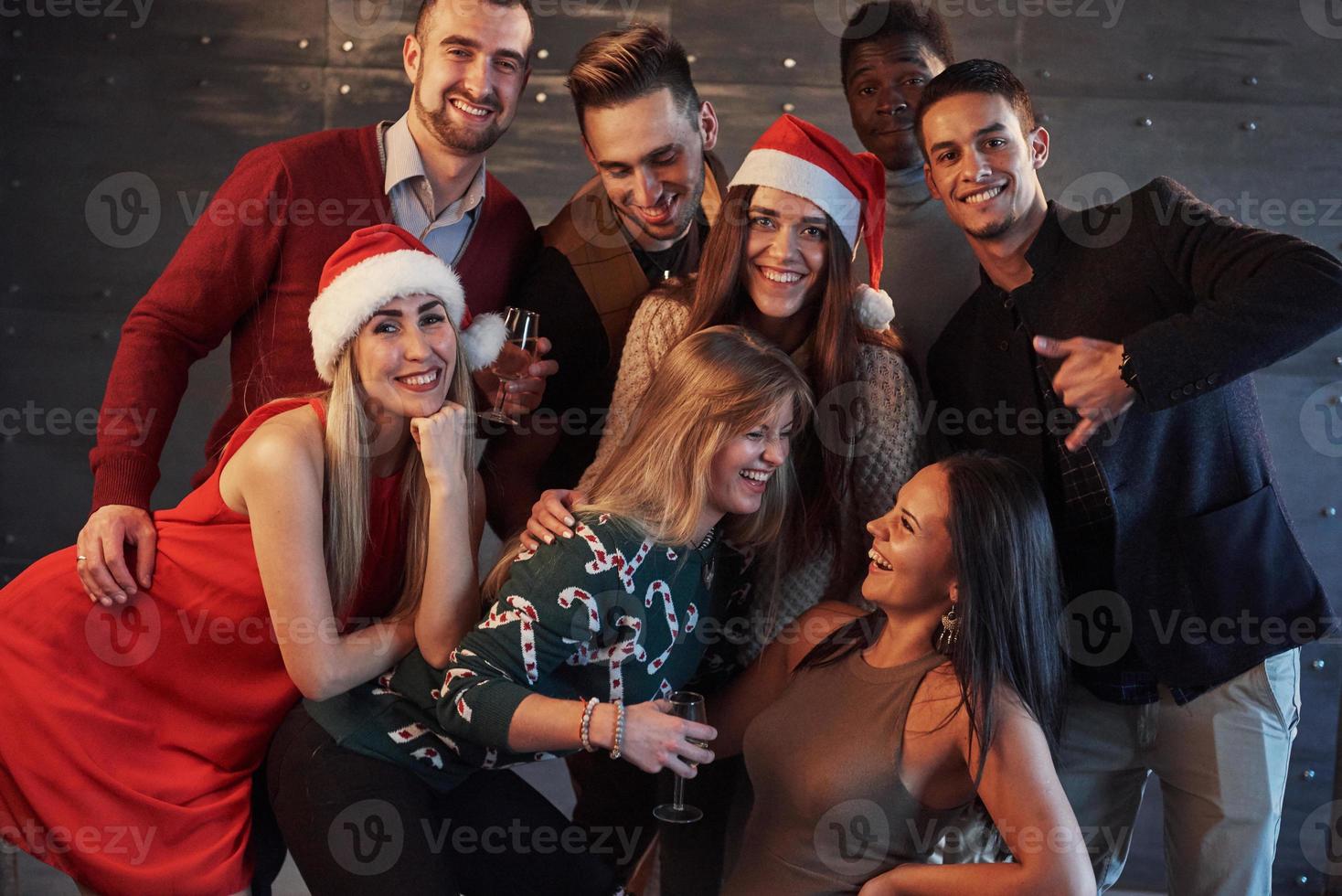 New Year is coming. Group of cheerful young multiethnic people in Santa hats on the party, posing emotional lifestyle people concept photo