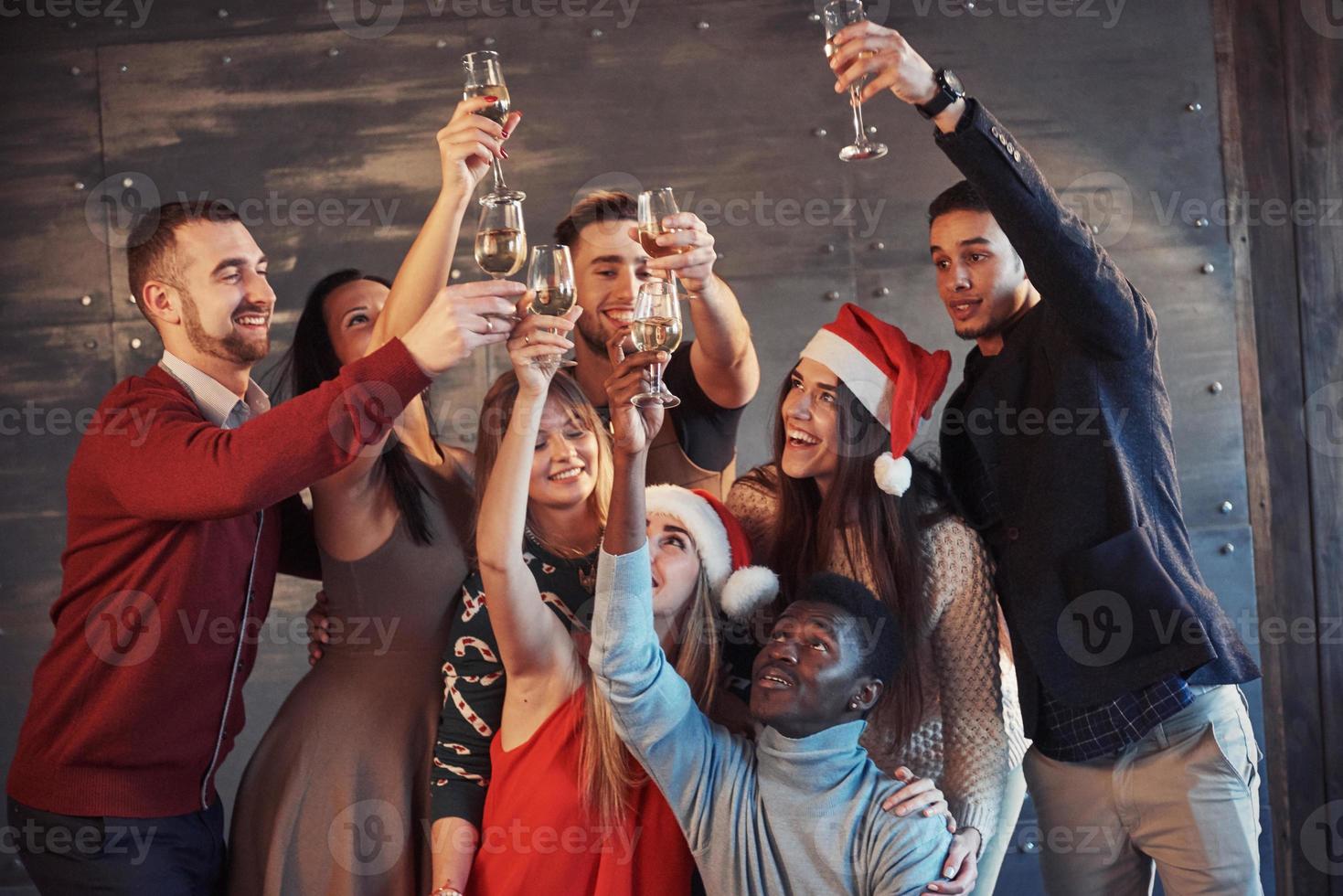 el nuevo año está llegando. Grupo de alegres jóvenes multiétnicos con gorro de Papá Noel en la fiesta, posando concepto de gente de estilo de vida emocional foto