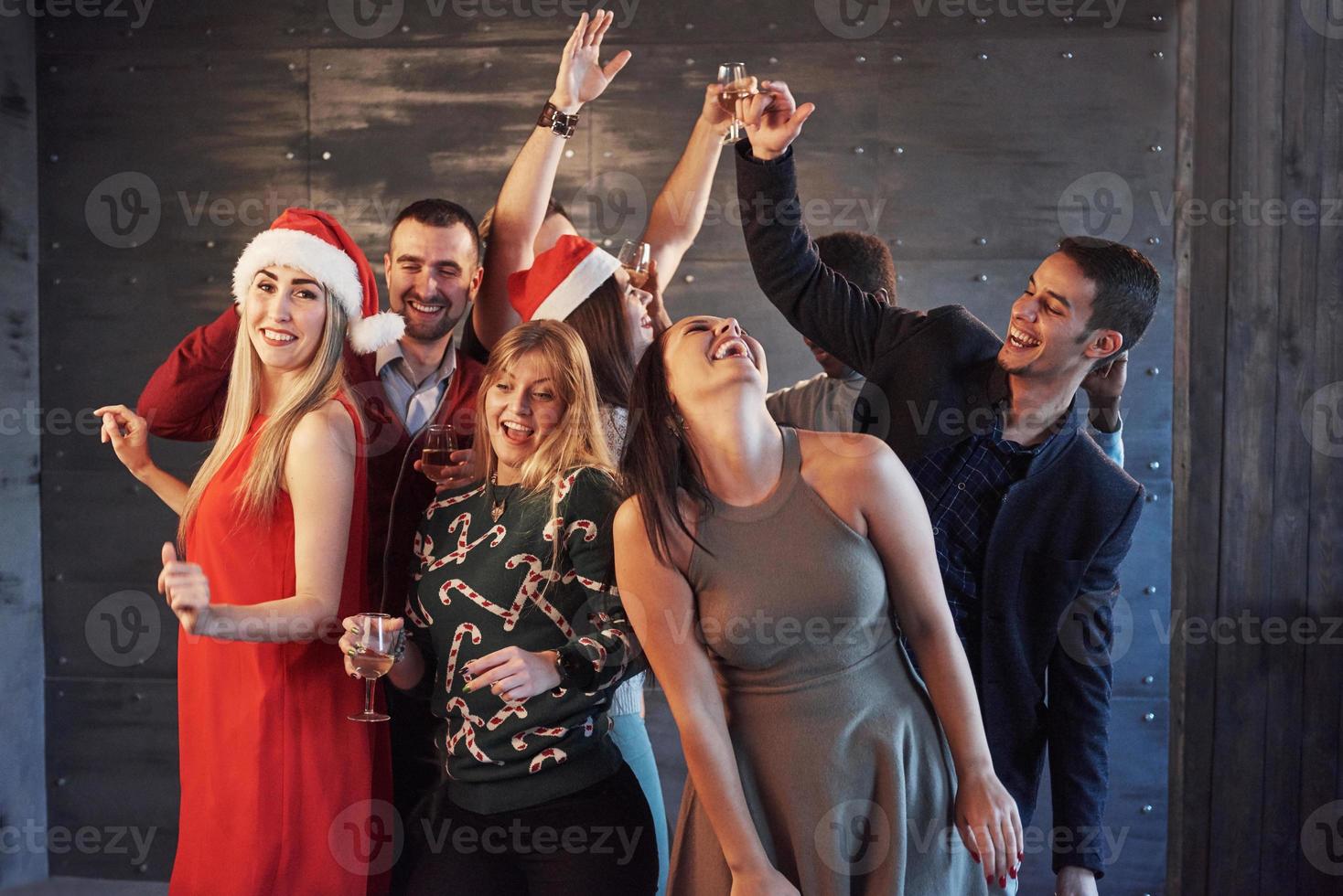 Party with friends. They love Christmas. Group of cheerful young people carrying sparklers and champagne flutes dancing in new year party and looking happy. Concepts about togetherness lifestyle photo