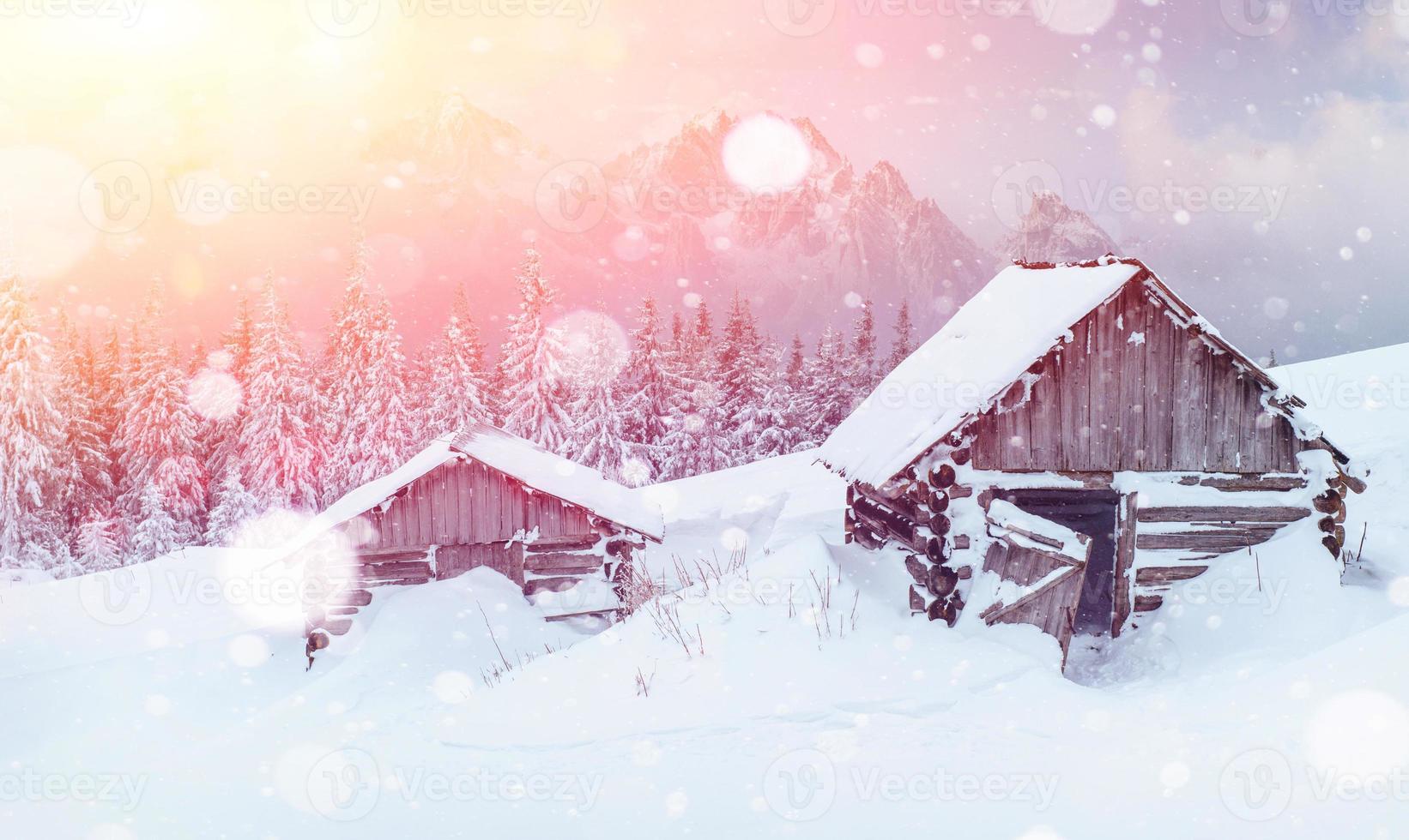 Hut in the mountains in winter, background with some soft highlights and snow flakes. Carpathians, Ukraine. photo