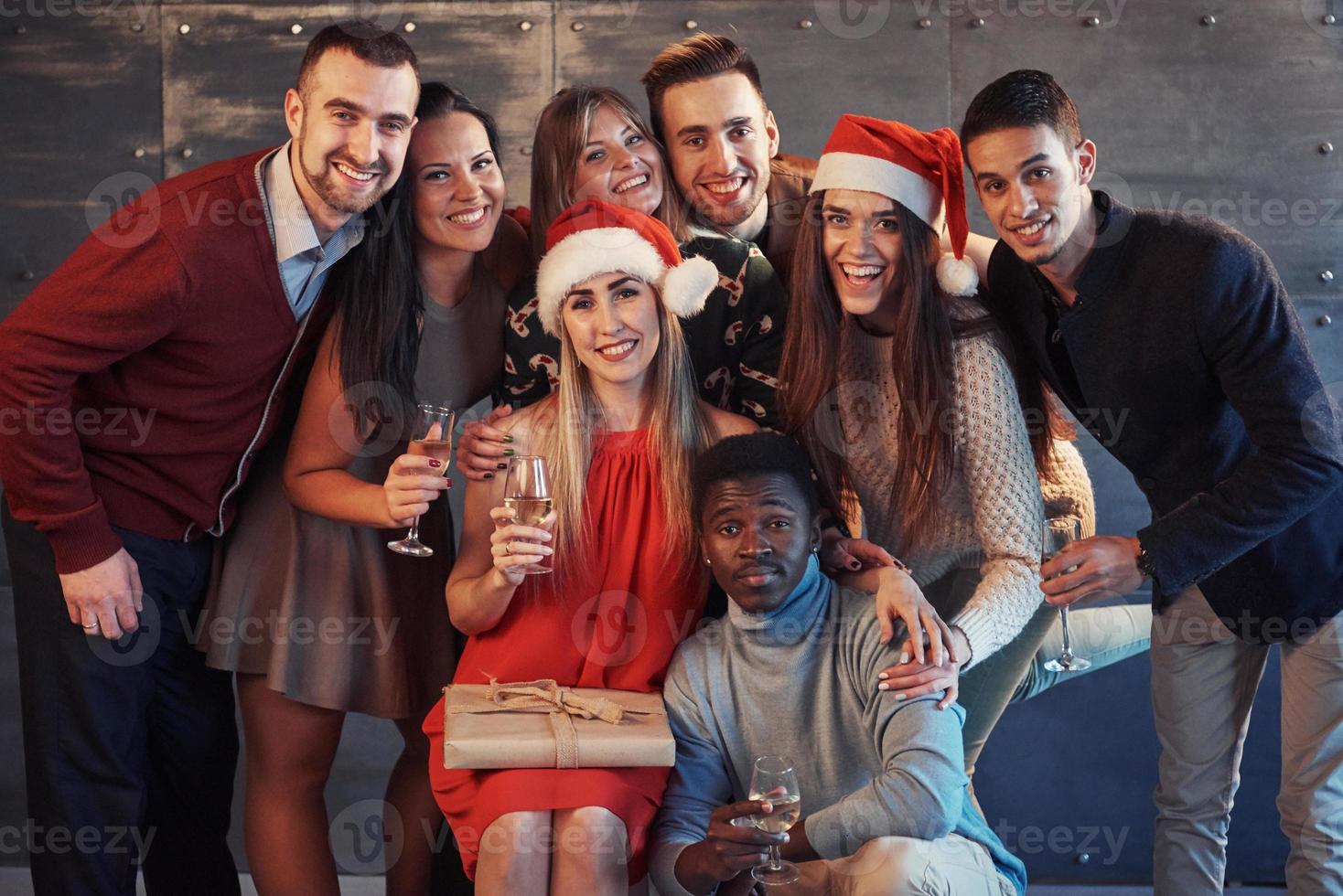 New Year is coming. Group of cheerful young multiethnic people in Santa hats on the party, posing emotional lifestyle people concept photo