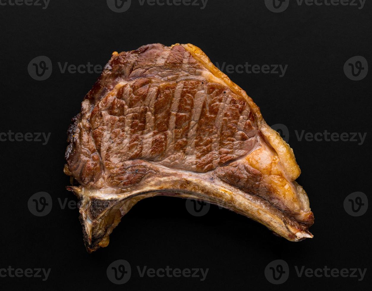 a piece of fresh grilled meat on black background photo