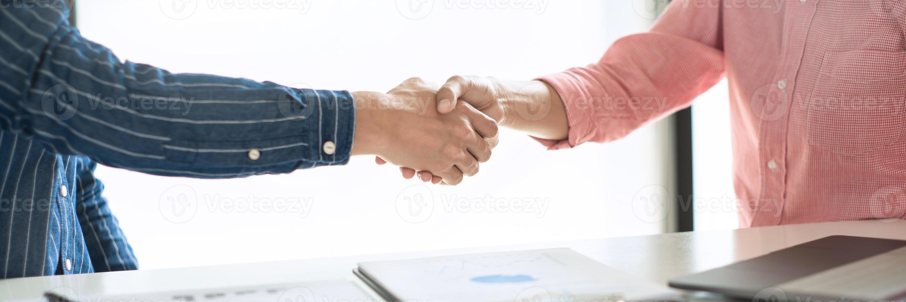 Two confident business man shaking hands during a meeting in the office, success, dealing, greeting and partner concept. photo