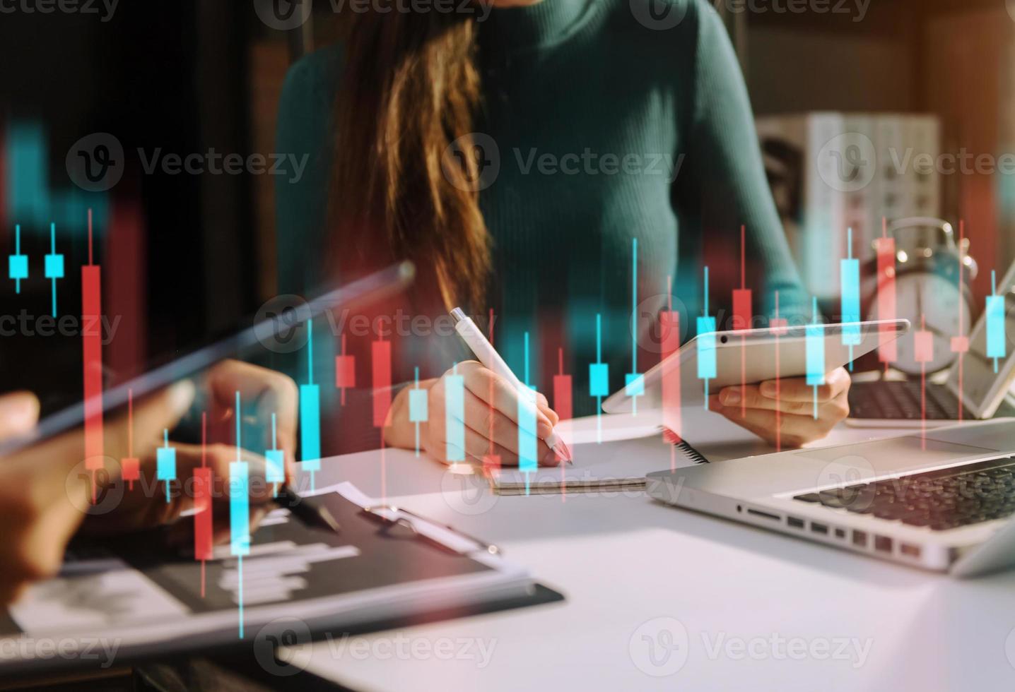 dos traides profesionales en el gráfico e indicador de precios técnicos, el gráfico de velas rojas y verdes y la computadora de negociación de acciones foto