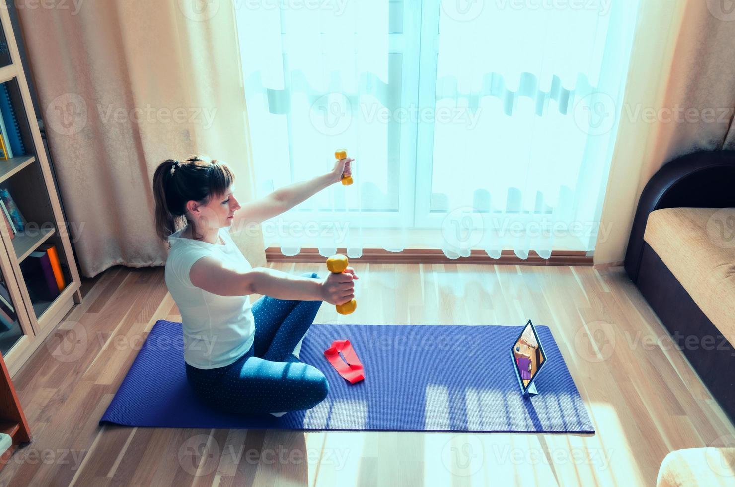 joven mujer atractiva en ropa deportiva haciendo ejercicio en casa foto