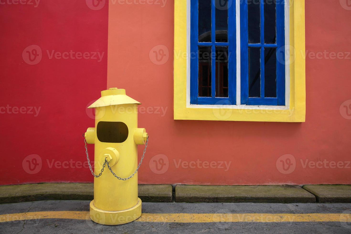 Colorful background of yellow fire hydrant in front of the house building photo