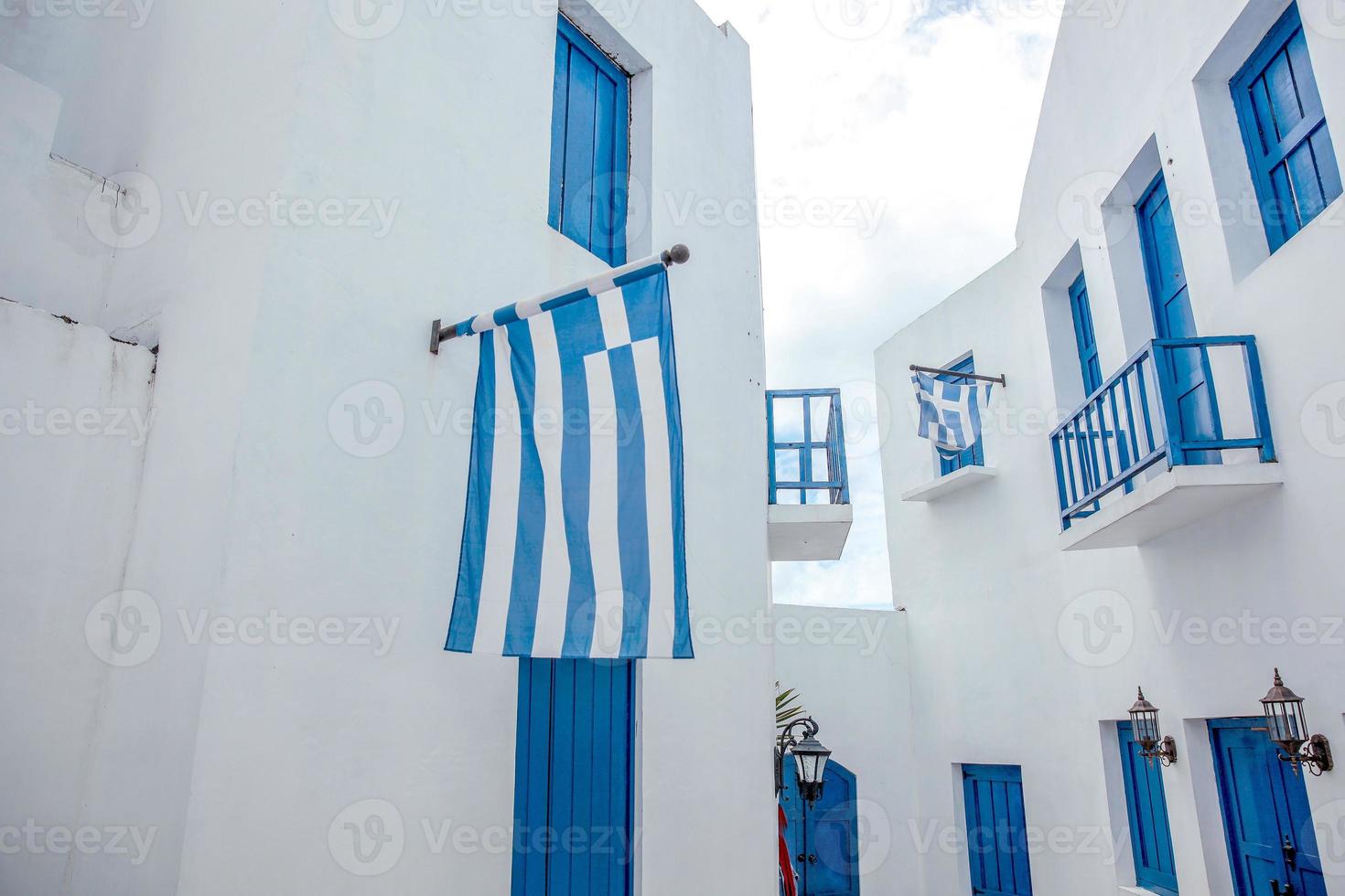 bandera griega en la pared de la casa tradicional blanca de Grecia foto