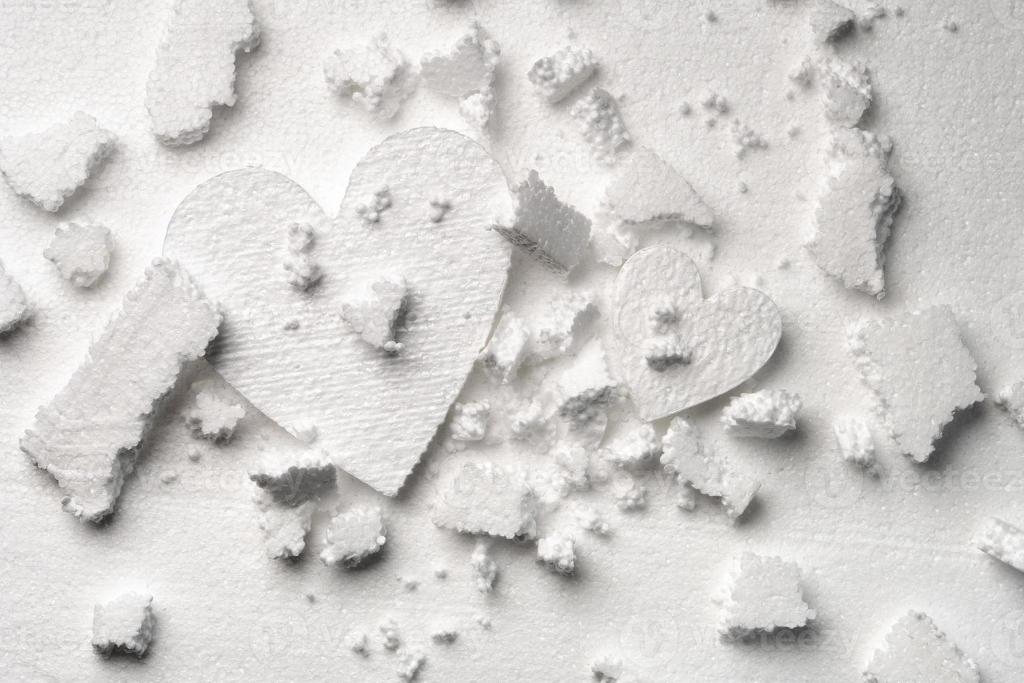 Two styrofoam hearts under the broken styrofoam fragments photo