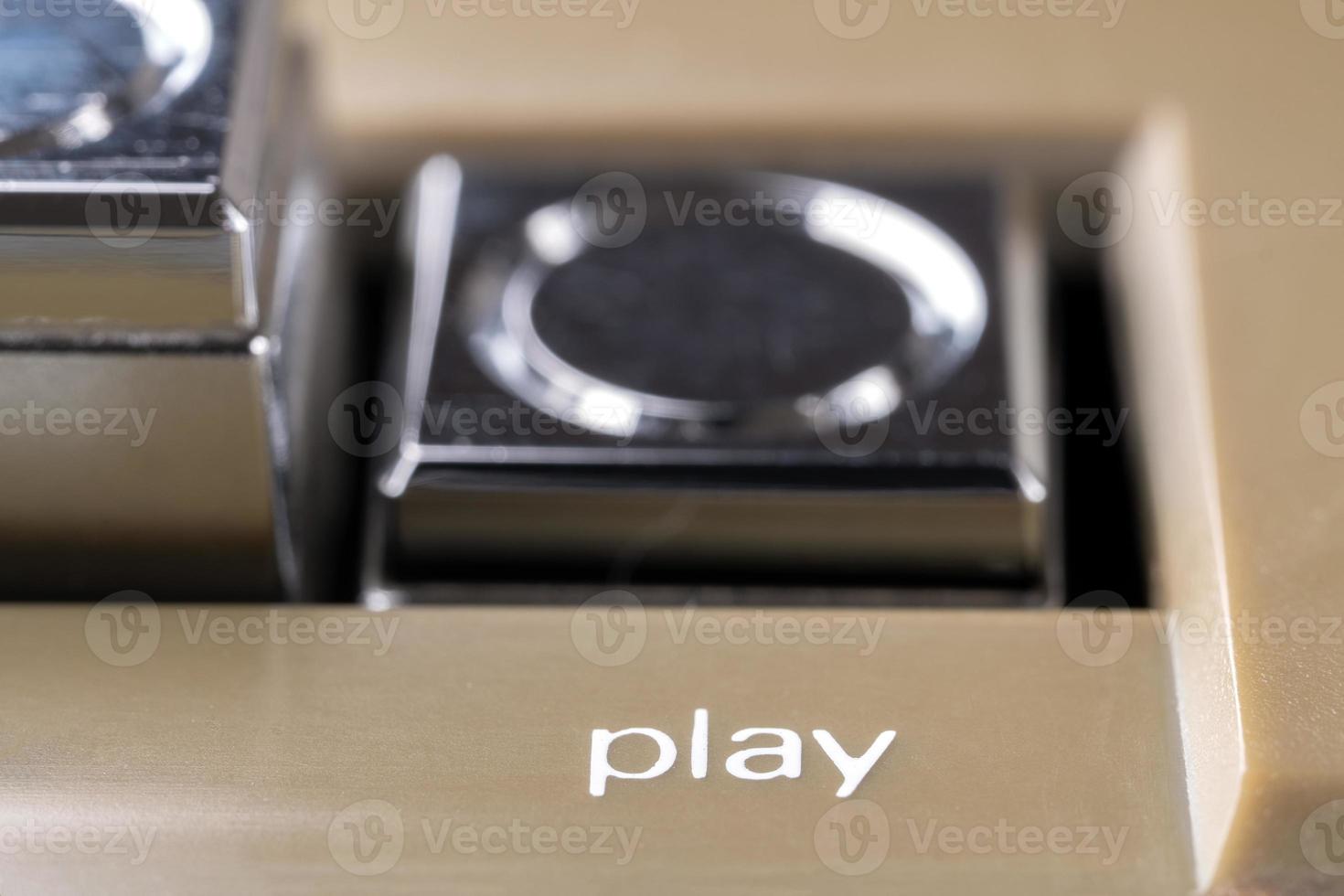 Pressed play button of a vintage tape recorder macro photo