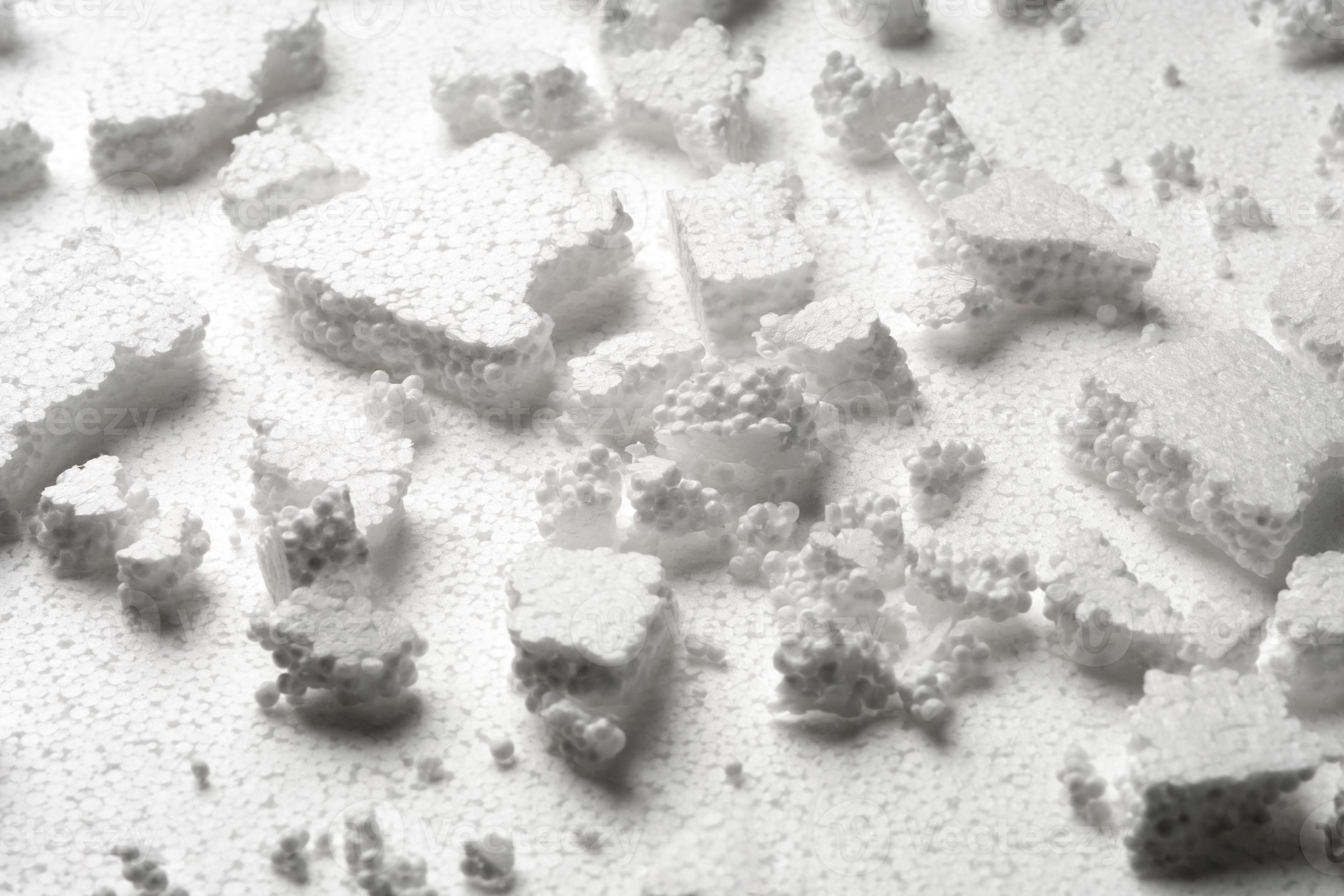 Broken pieces of white styrofoam on the sheet of white styrofoam