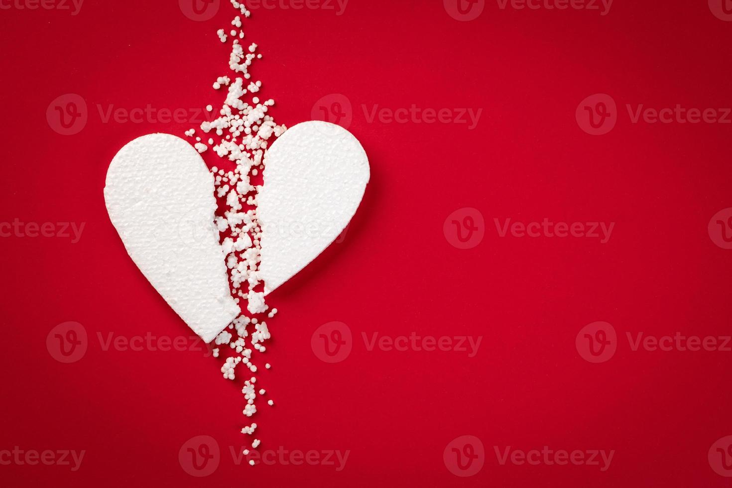 Background with white broken styrofoam heart on a red backdrop photo