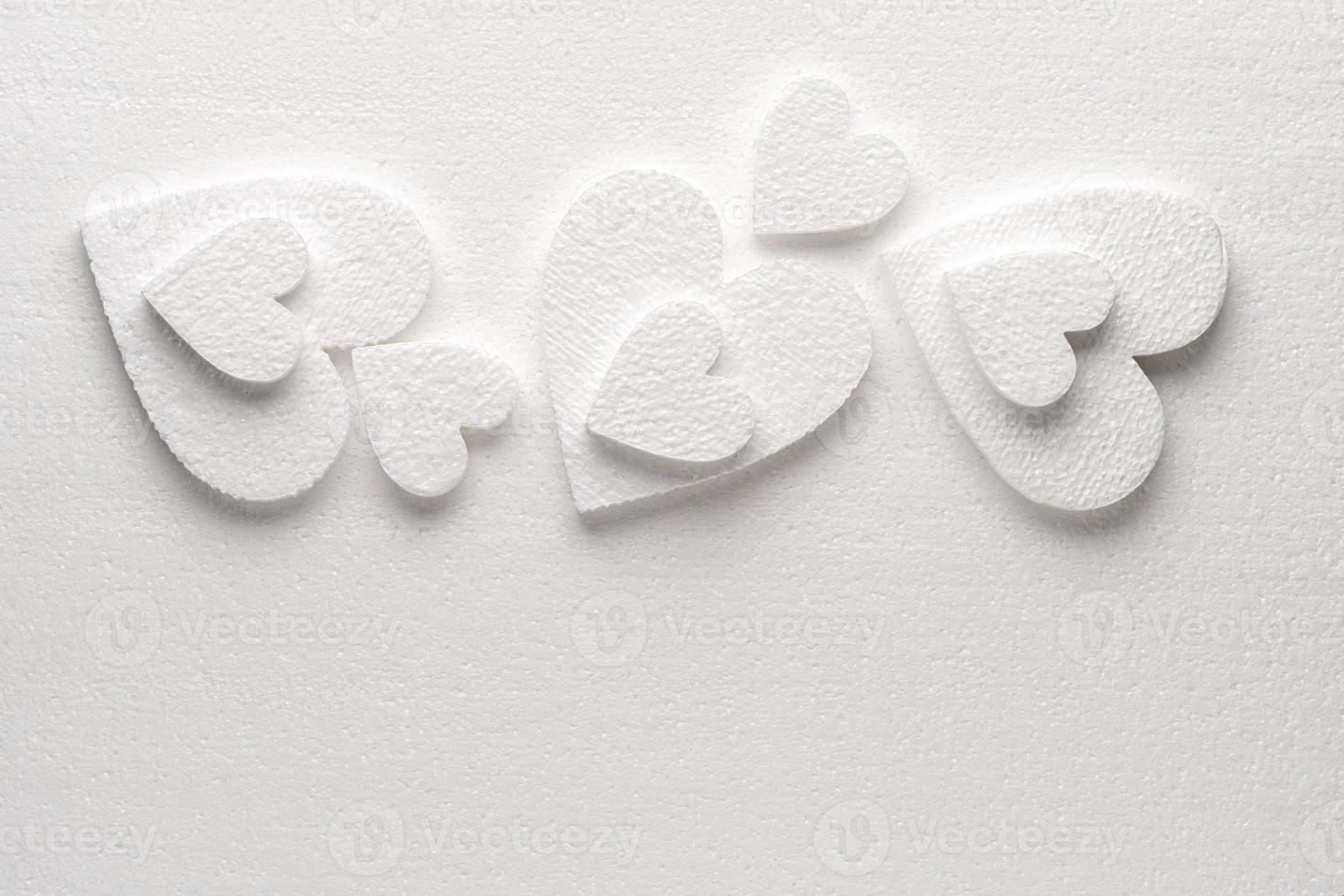 Pattern of white styrfoam hearts on the sheet of a white styrfoam photo