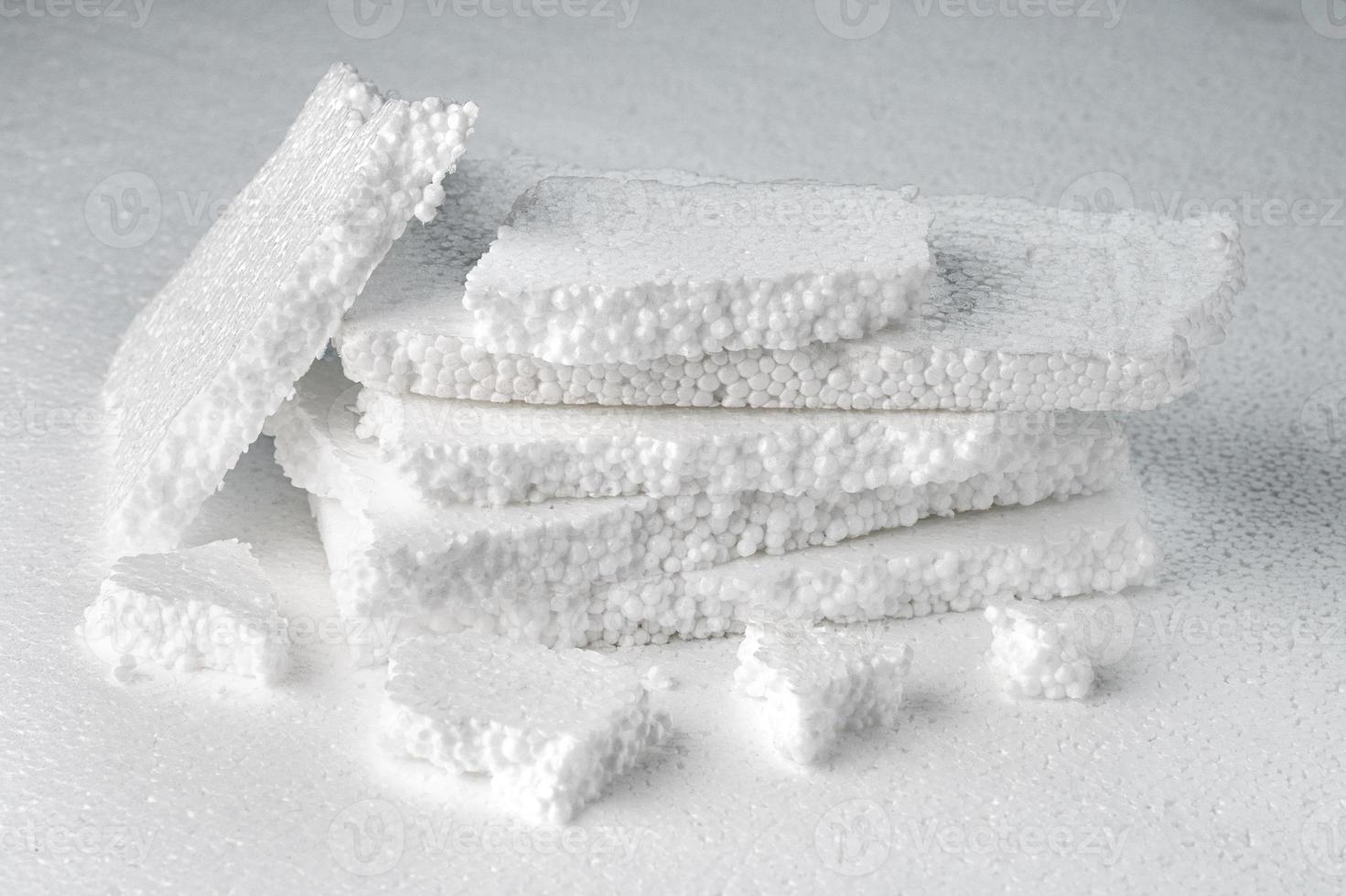 Stack of broken pieces of white styrofoam on the sheet of white styrofoam photo