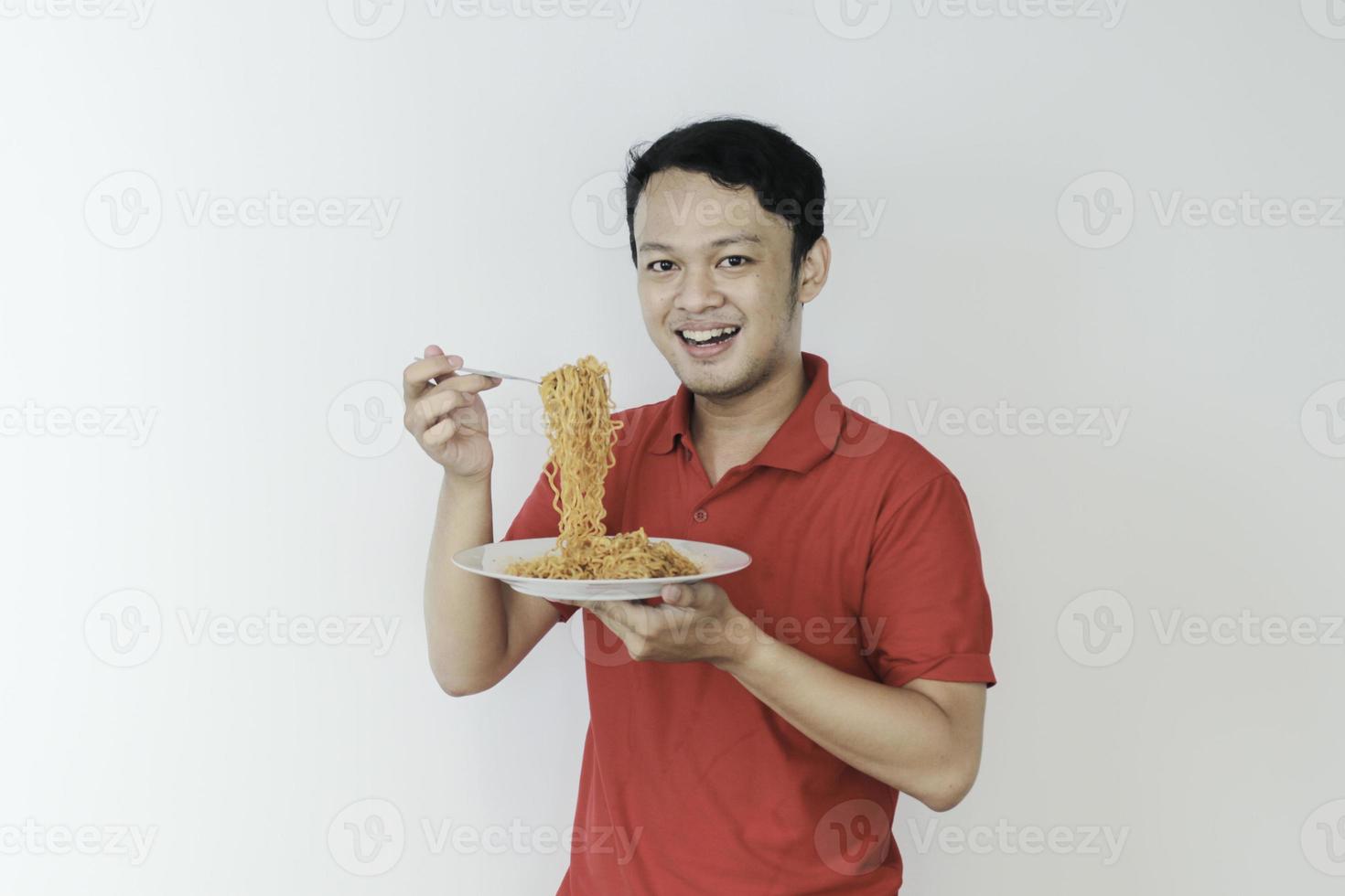 Portrait of happy Young Asian man enjoys noodles. Eating lunch concept. photo