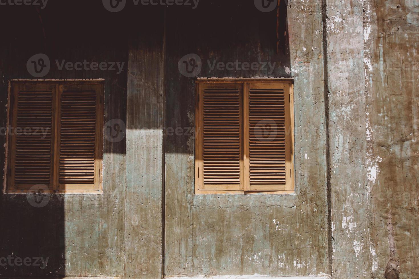 dos ventanas de madera con paredes sucias en la casa antigua foto