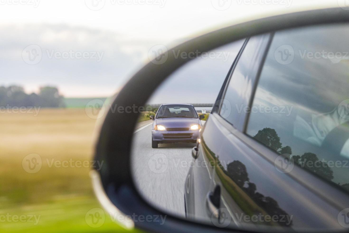 Purple car in the rearview mirror on the highway Sweden. photo