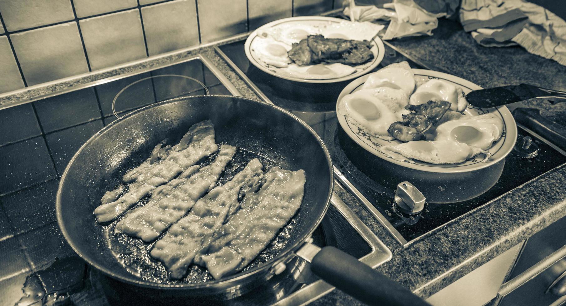 Fry eggs make fried eggs ham sausages in the pan. photo