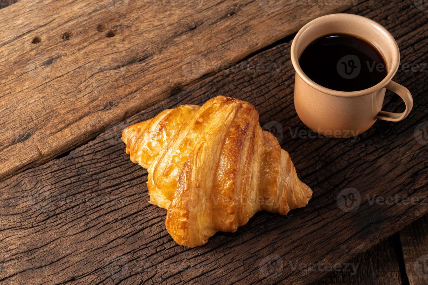 breakfast food coffee and croissant on isolated wood table. photo