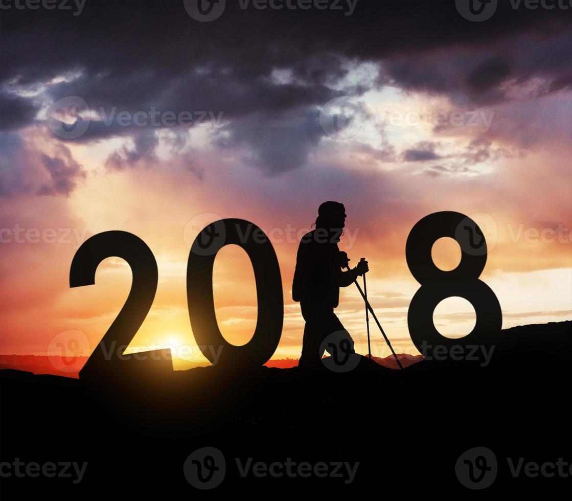 Silhouette young hiker man for 2018 new year background of the sunset photo