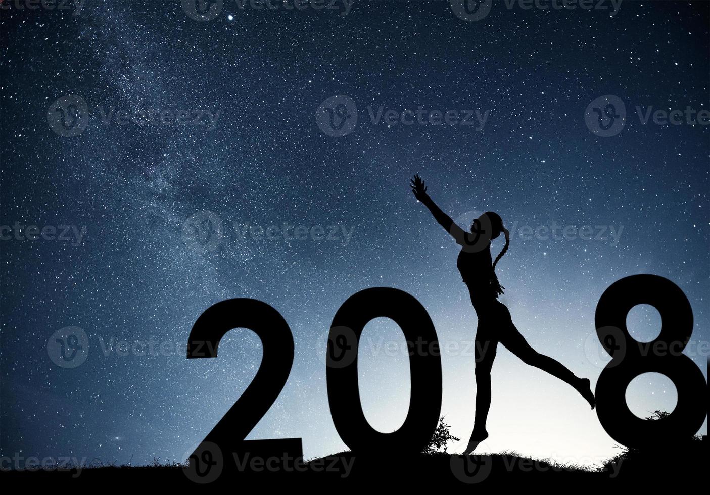 Silhouette young girl. Happy 2018 new year. Background of the Milky Way galaxy on a bright star dark sky tone photo