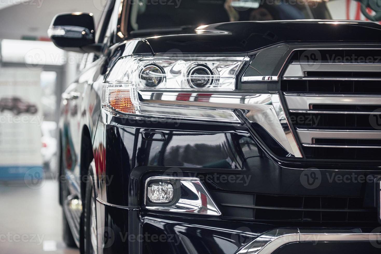 The headlights and the hood of a black luxury car photo