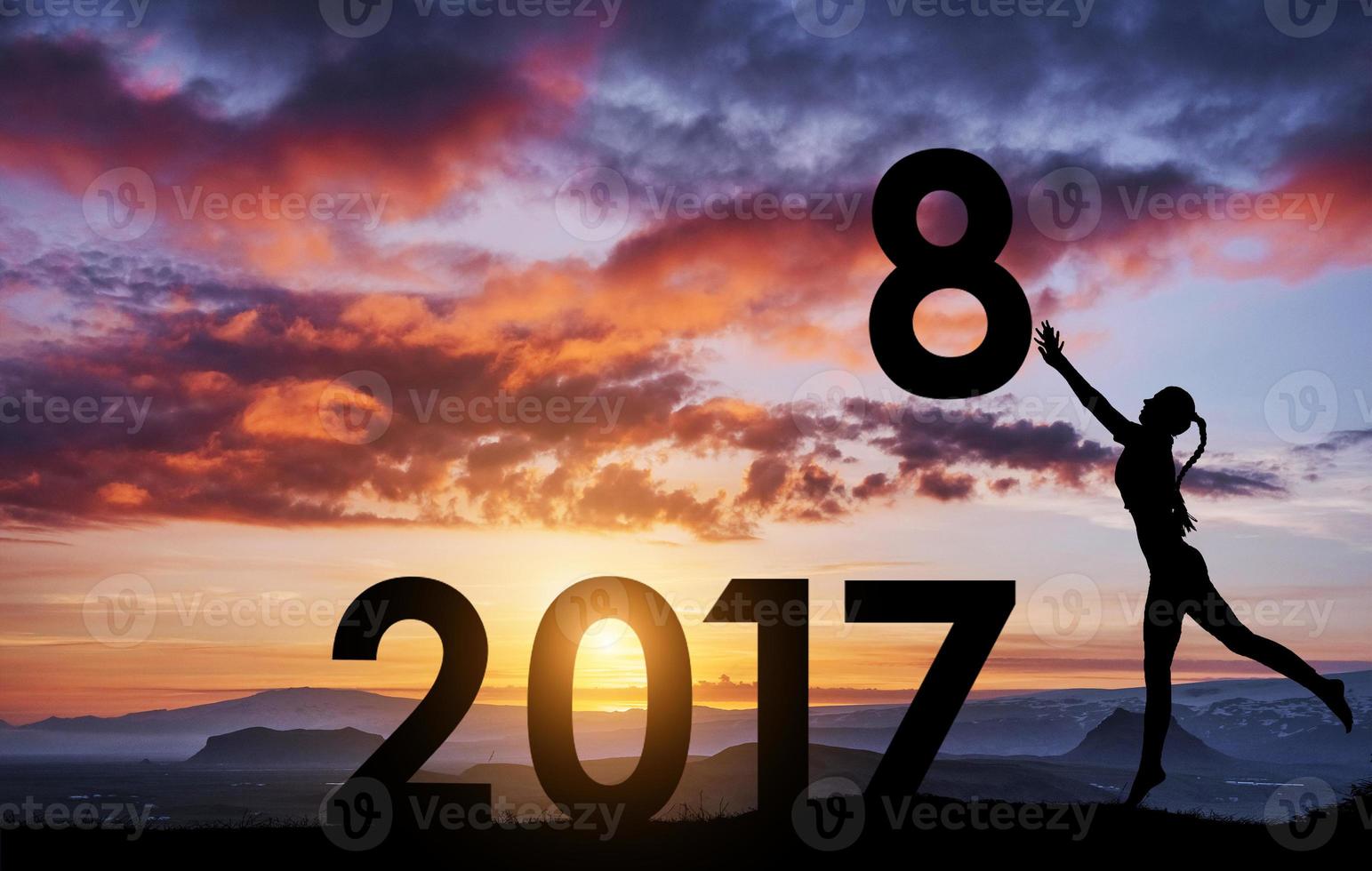 Silhouette of the girl who holds the numbers of the new year in the sunset. Concept of replacement 2017 to 2018 photo