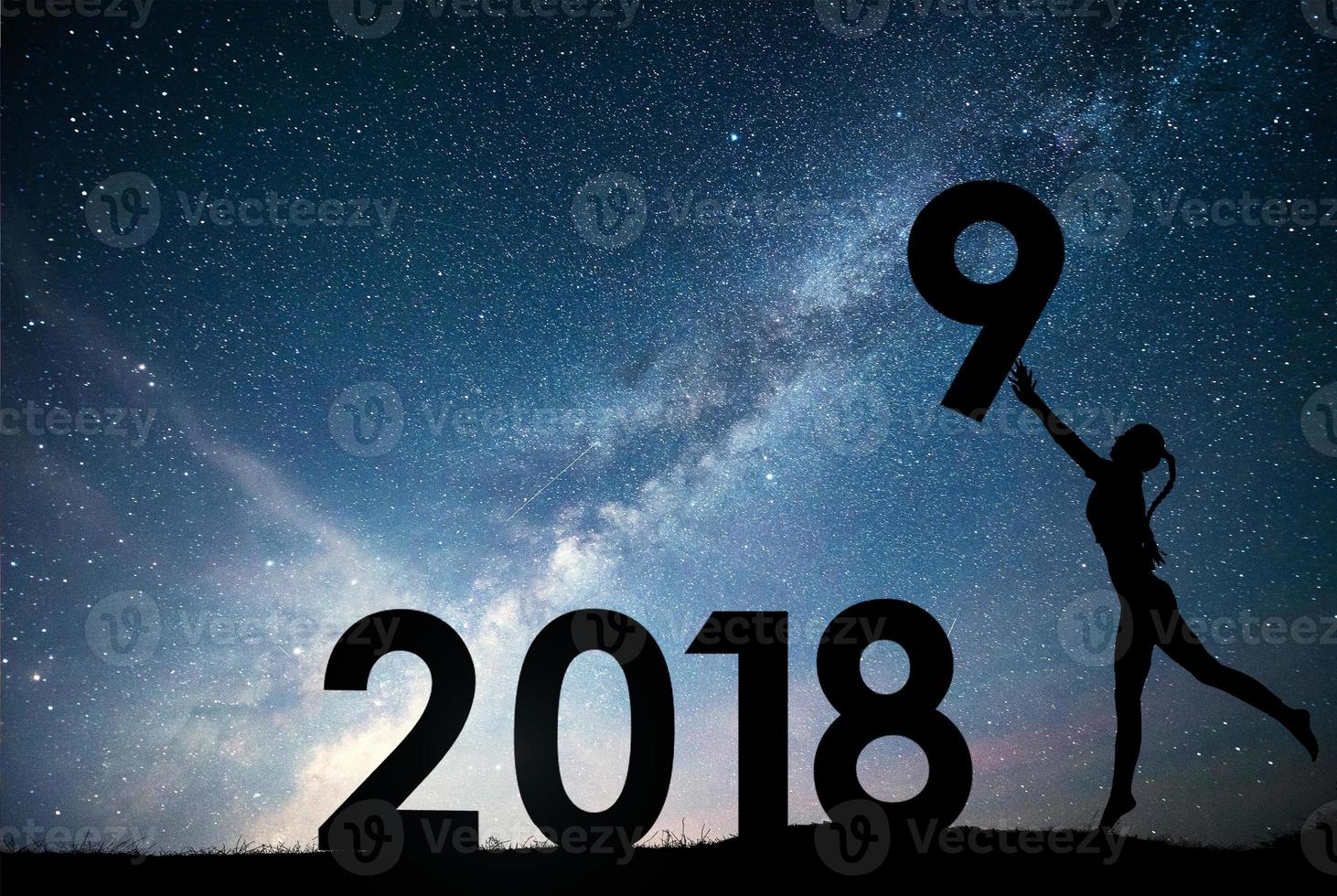 Silhouette young girl. Happy 2018 new year. Background of the Milky Way galaxy on a bright star dark sky tone. Concept change year 2017 to 2018 photo