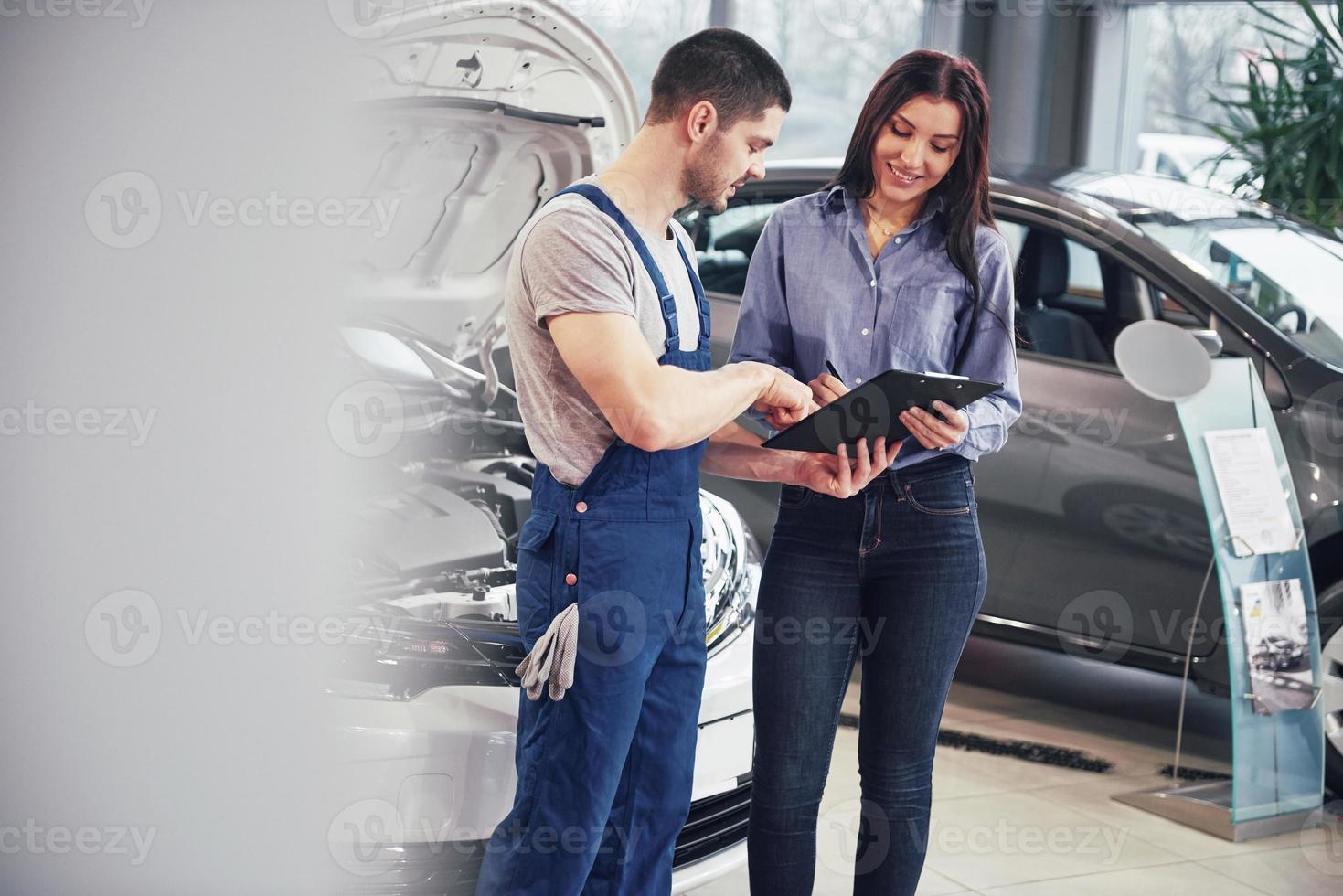 A man mechanic and woman customer discussing repairs done to her vehicle photo