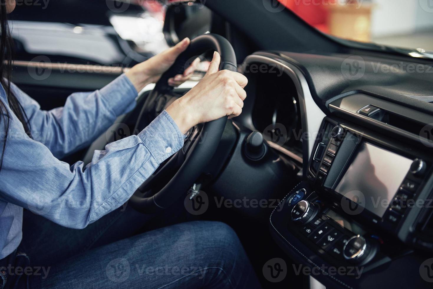 auto business, car sale, consumerism and people concept - happy woman taking car key from dealer in auto show or salon photo